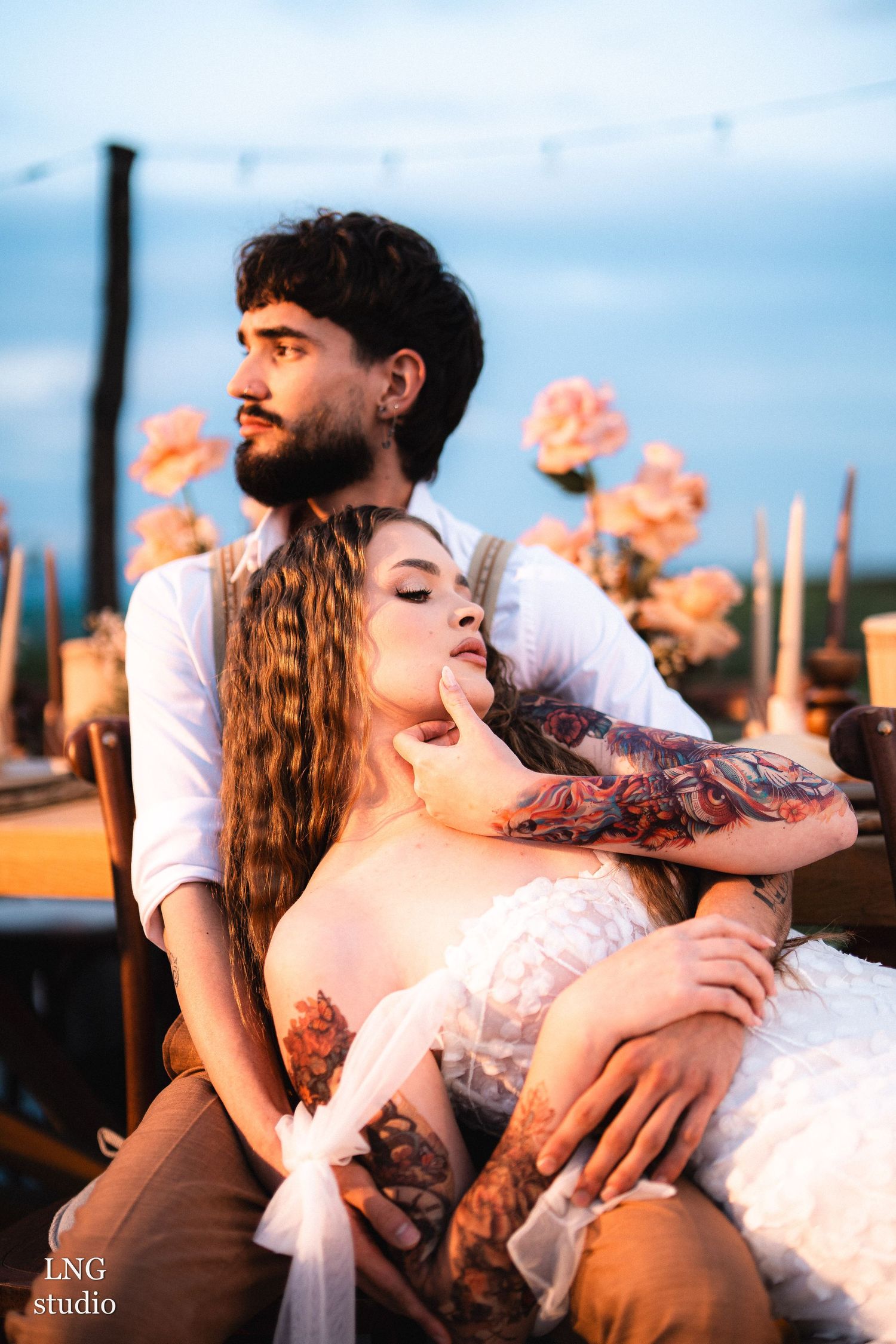 Dreamy outdoor portrait session featuring couple lying together in warm sunlight with ethereal ambiance.