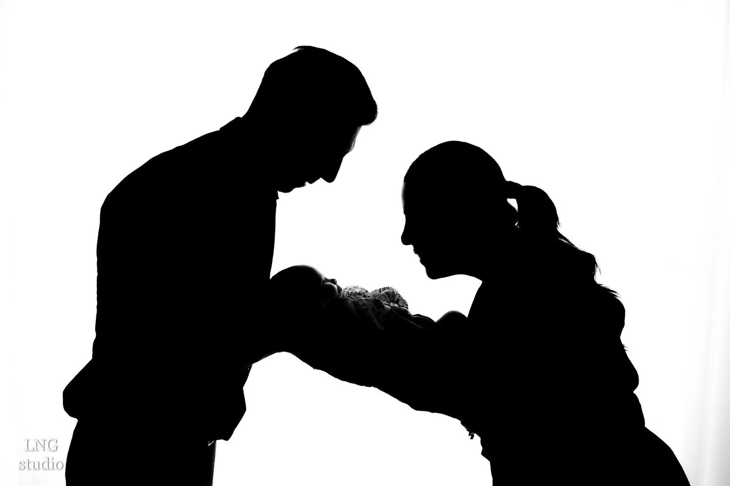 Black and white silhouettes show family interacting in minimalist studio setting.