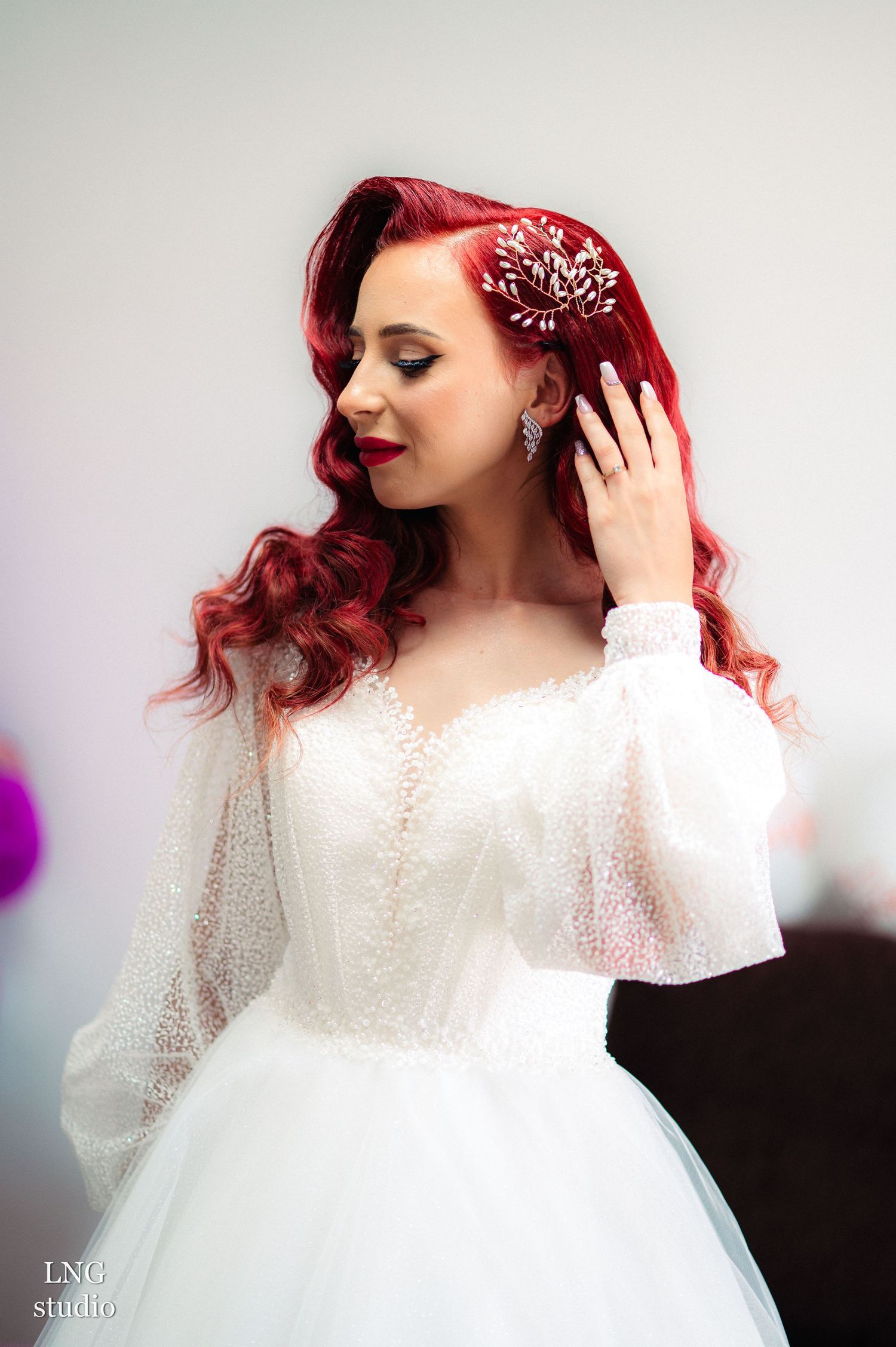 White lace wedding dress with sheer sleeves photographed in a soft, dreamy style.