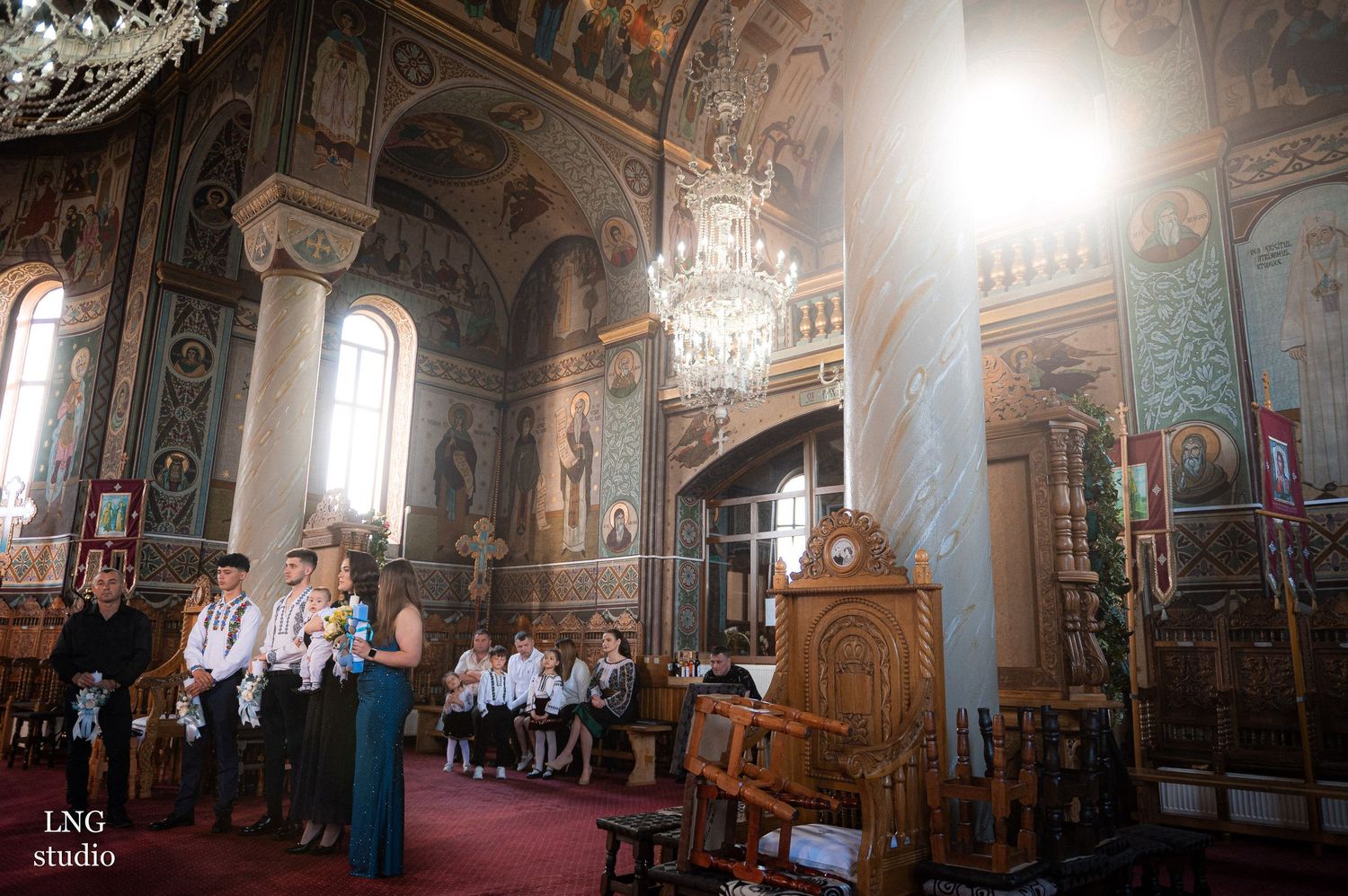 Interior panorama of an ornate Orthodox church with painted walls and natural lighting.