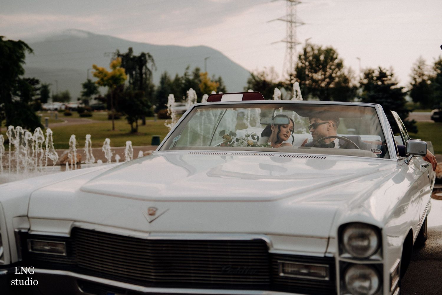 White classic 1960s Cadillac convertible parked at multiple angles showing its elegant lines and chrome details.