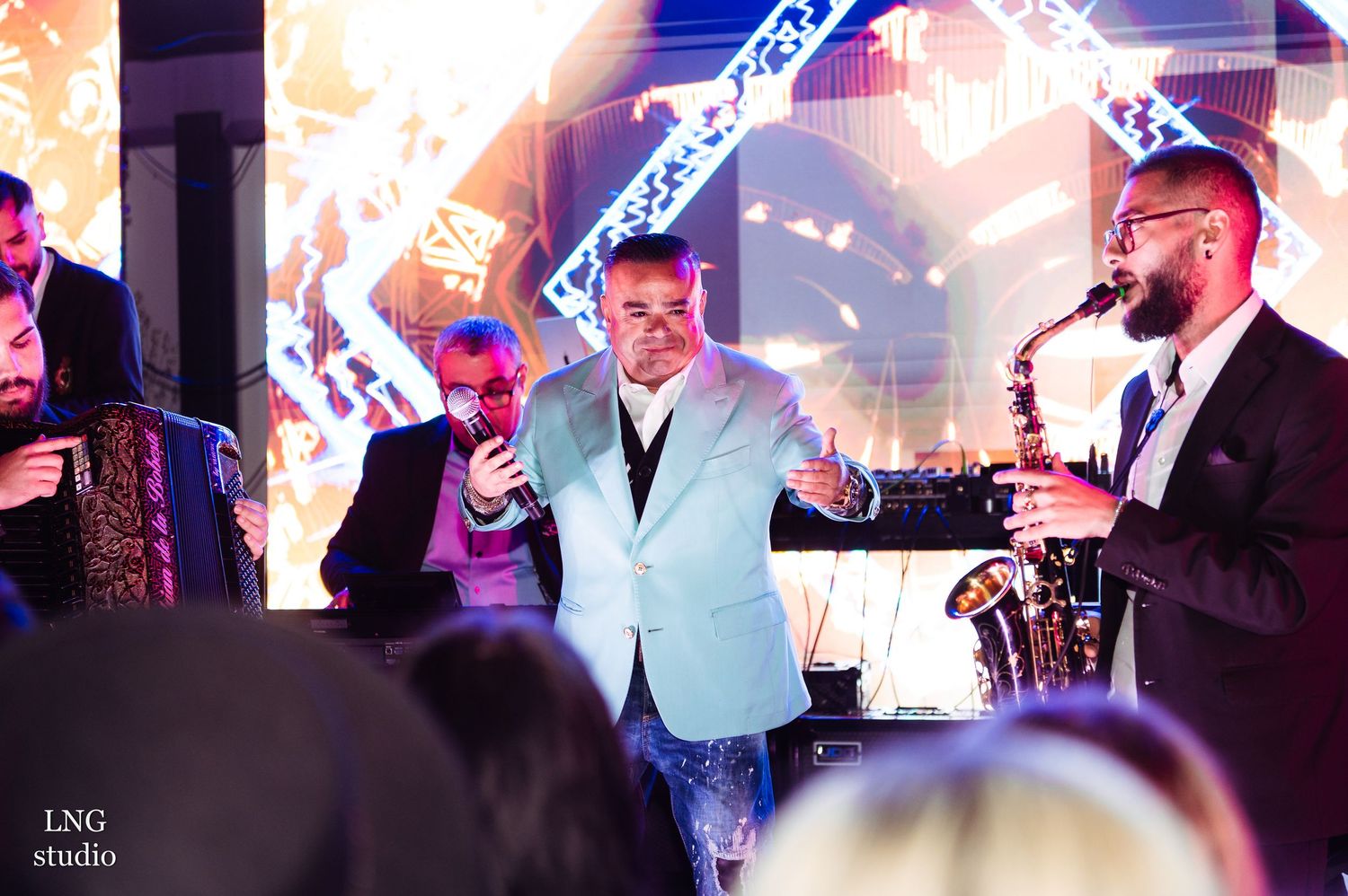 Concert performers on stage with dramatic lighting and special effects.