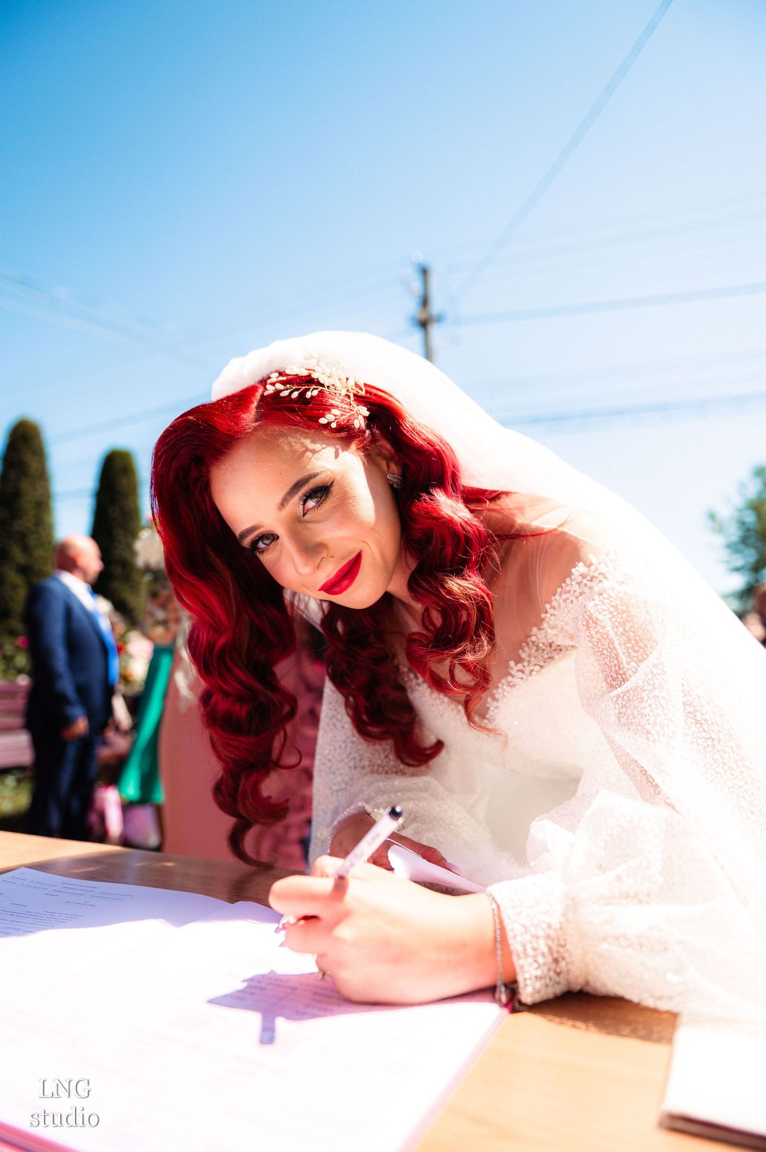 Wedding document signing outdoors on a bright sunny day with blue skies.