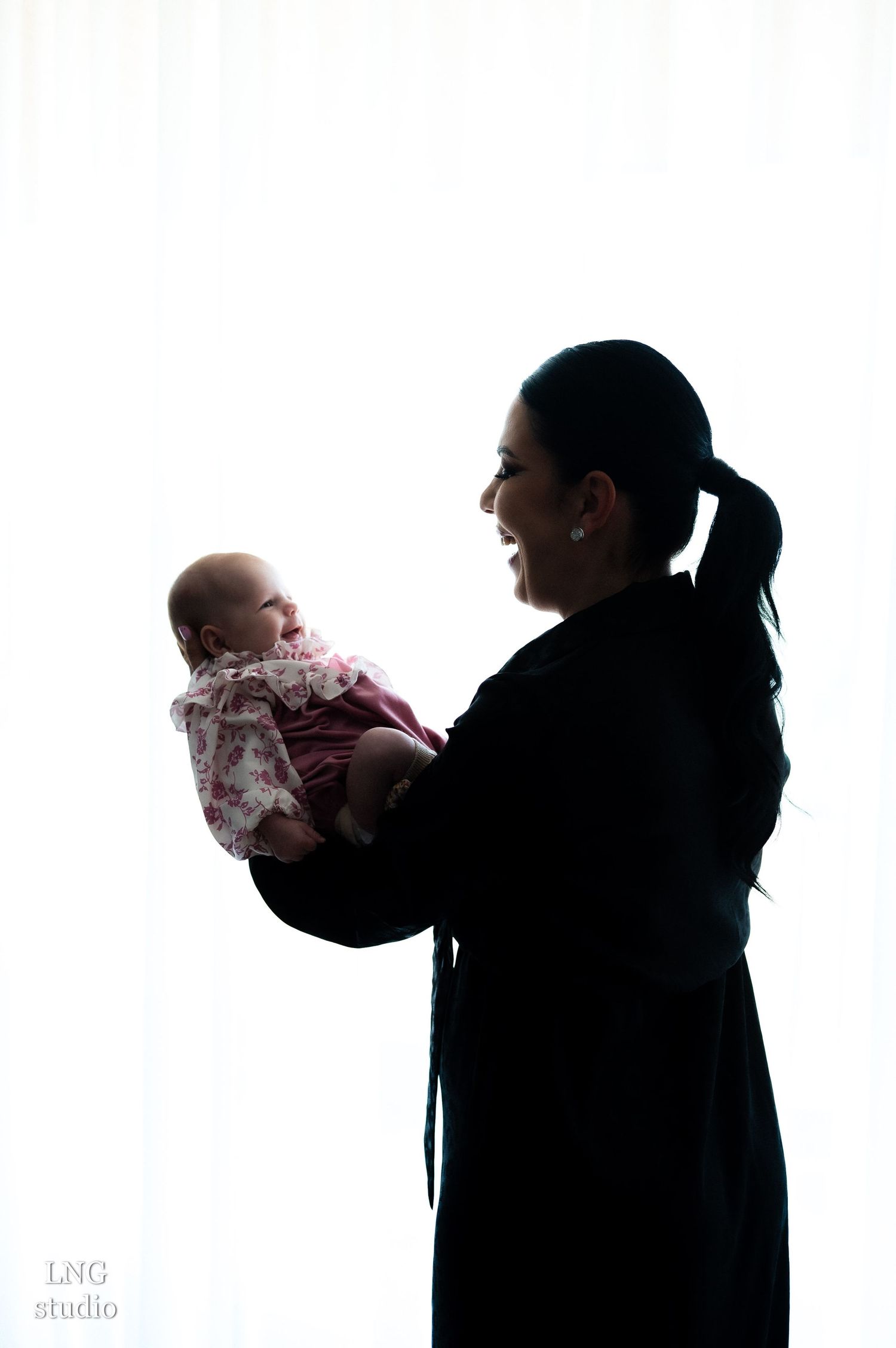 Artistic black and white silhouettes show family bonding moments in studio.