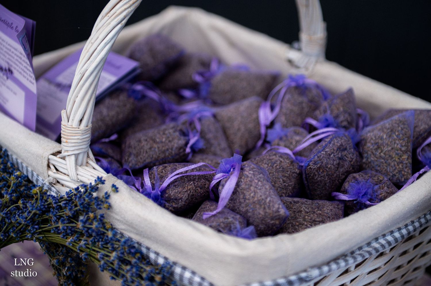 Dried lavender flowers and buds in white storage baskets with purple lighting.