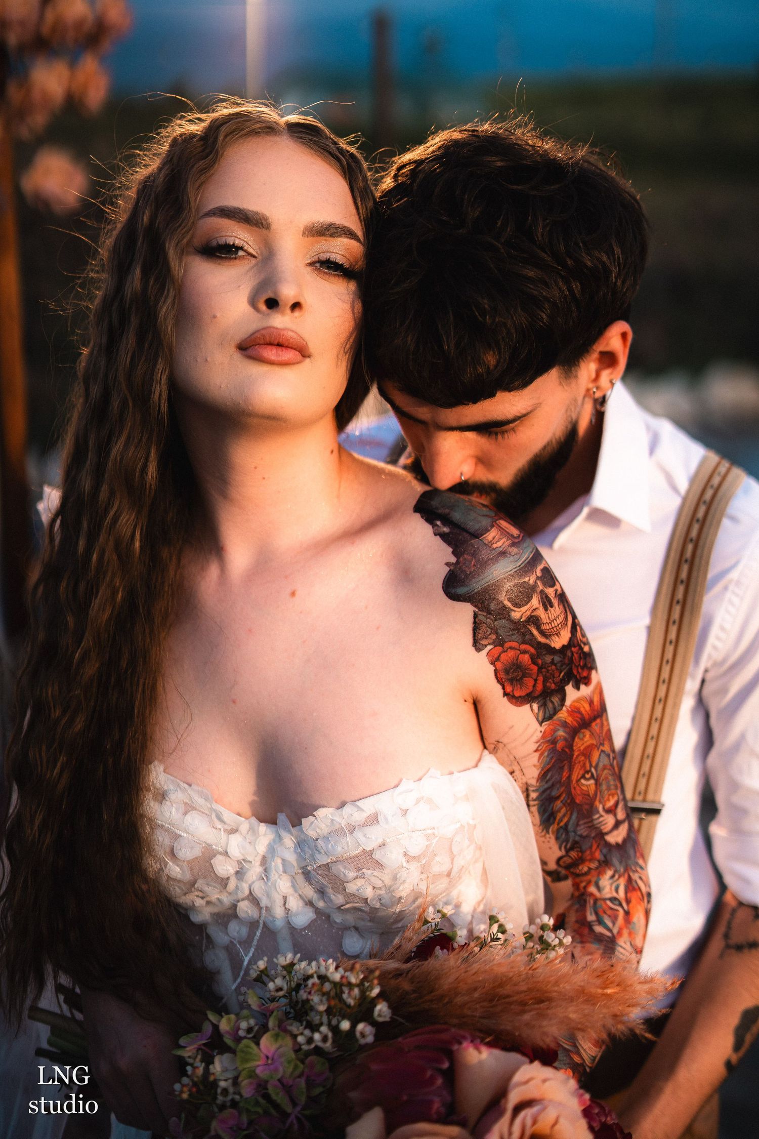 Romantic golden hour photoshoot showing couple in intimate embrace with sun-lit tones and artistic composition.