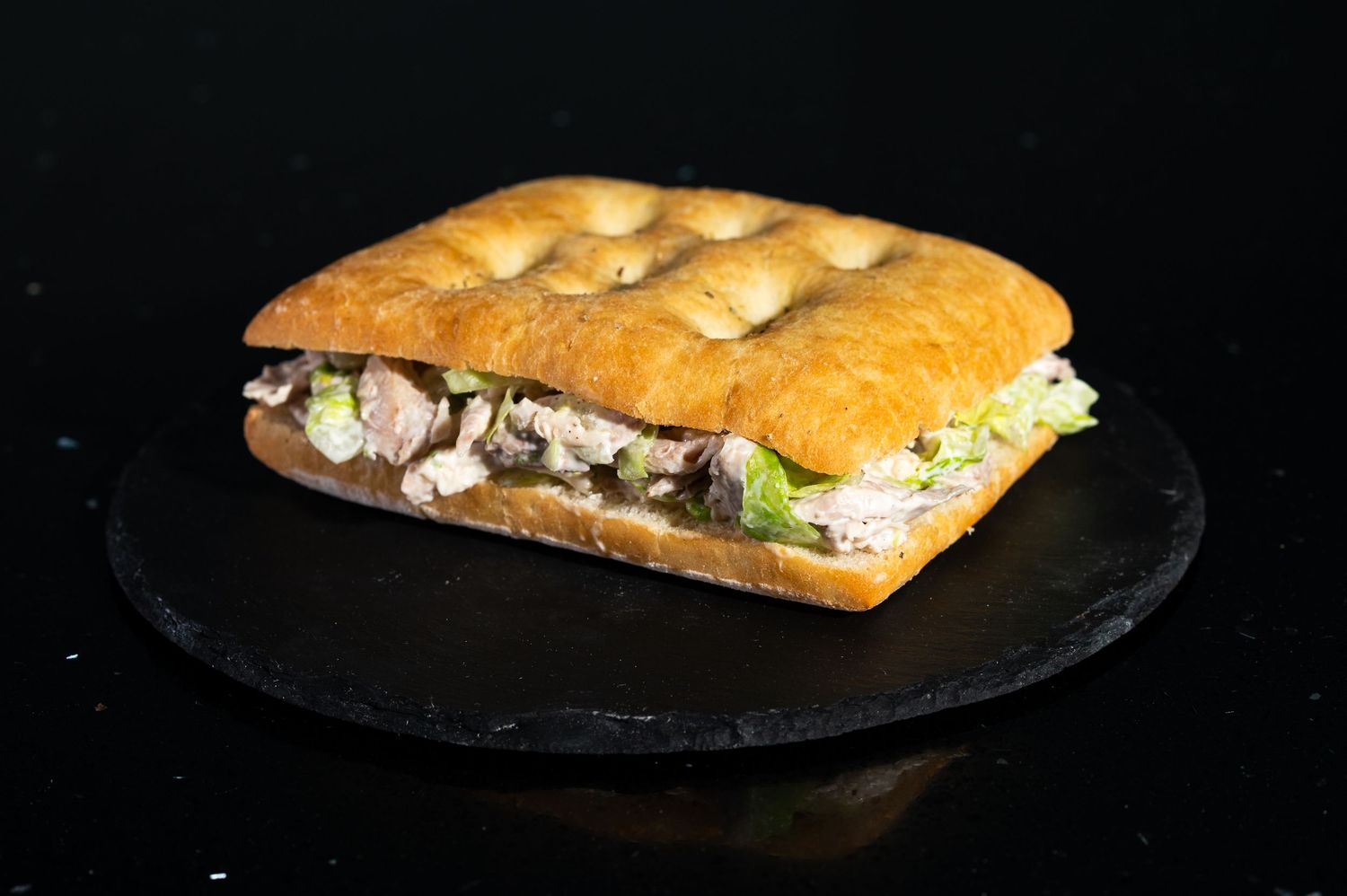 A deli-style submarine sandwich with meat and vegetables on fresh bread.