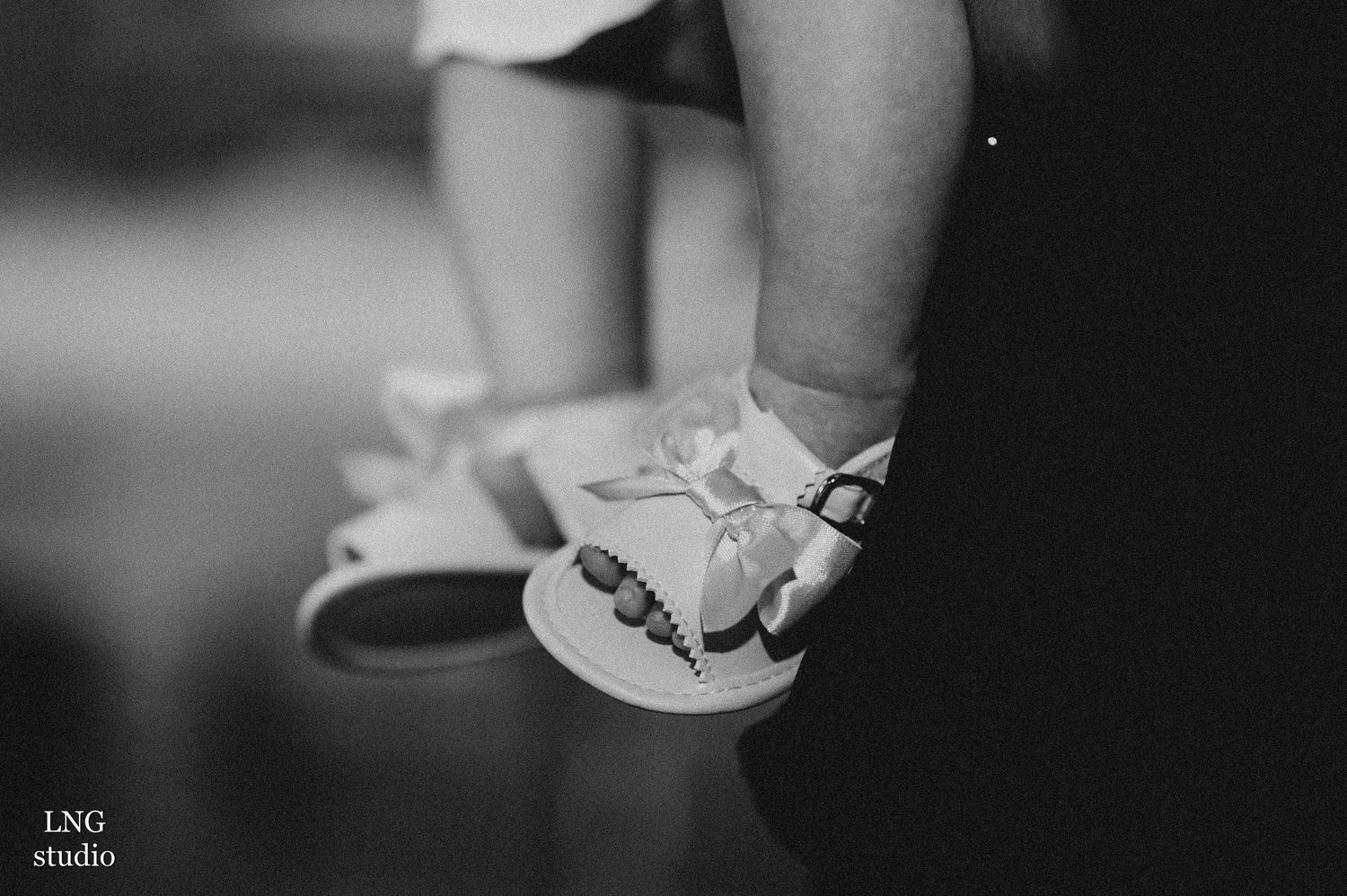 Close-up of small white baby shoes in black and white photography.