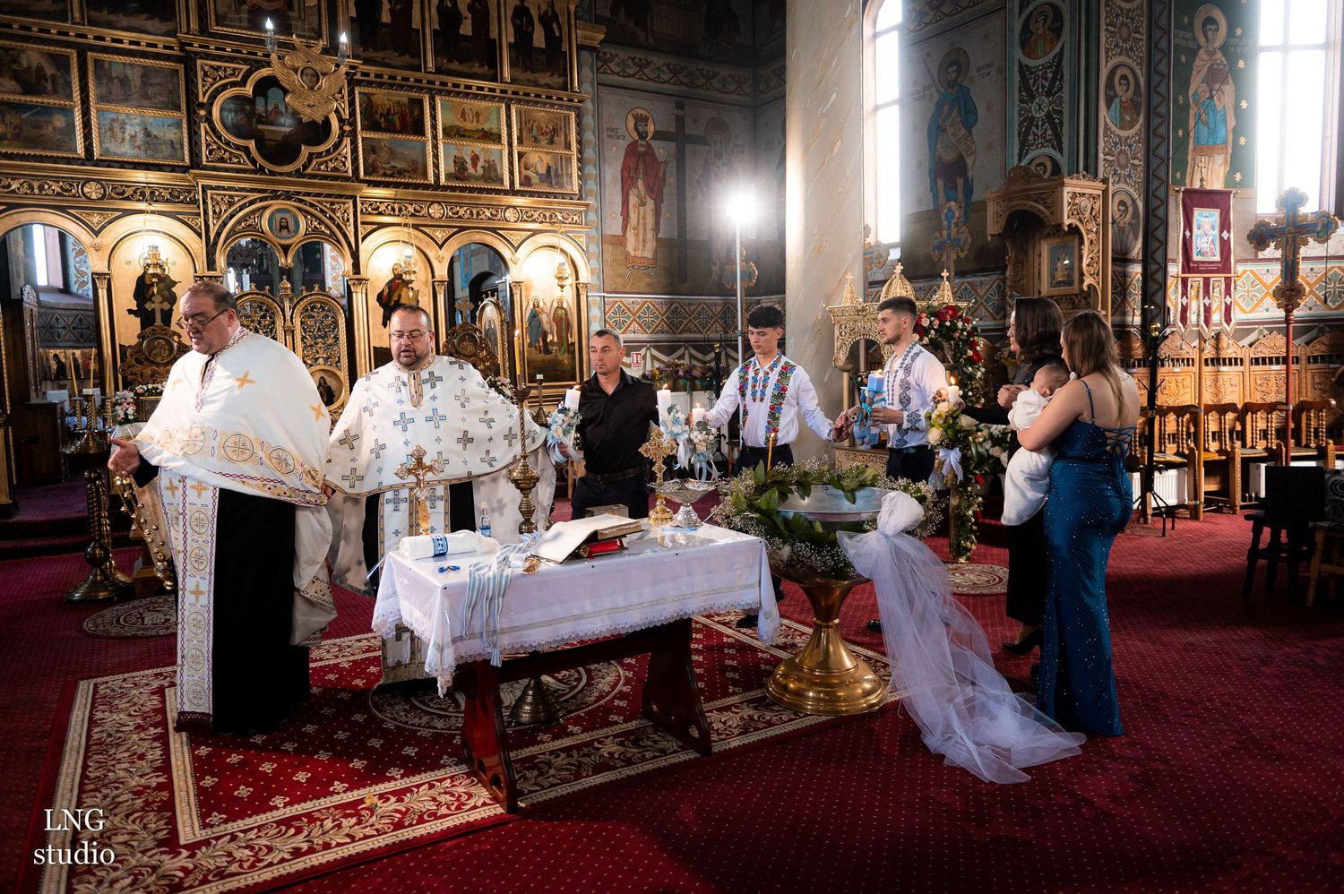 Religious ceremony being performed at an altar in an Orthodox church with elaborate decorations.