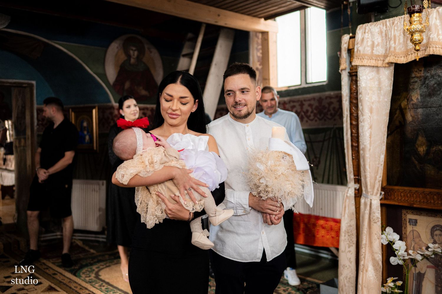 Candlelit ceremony taking place in a traditional Orthodox church interior with ornate decorations.