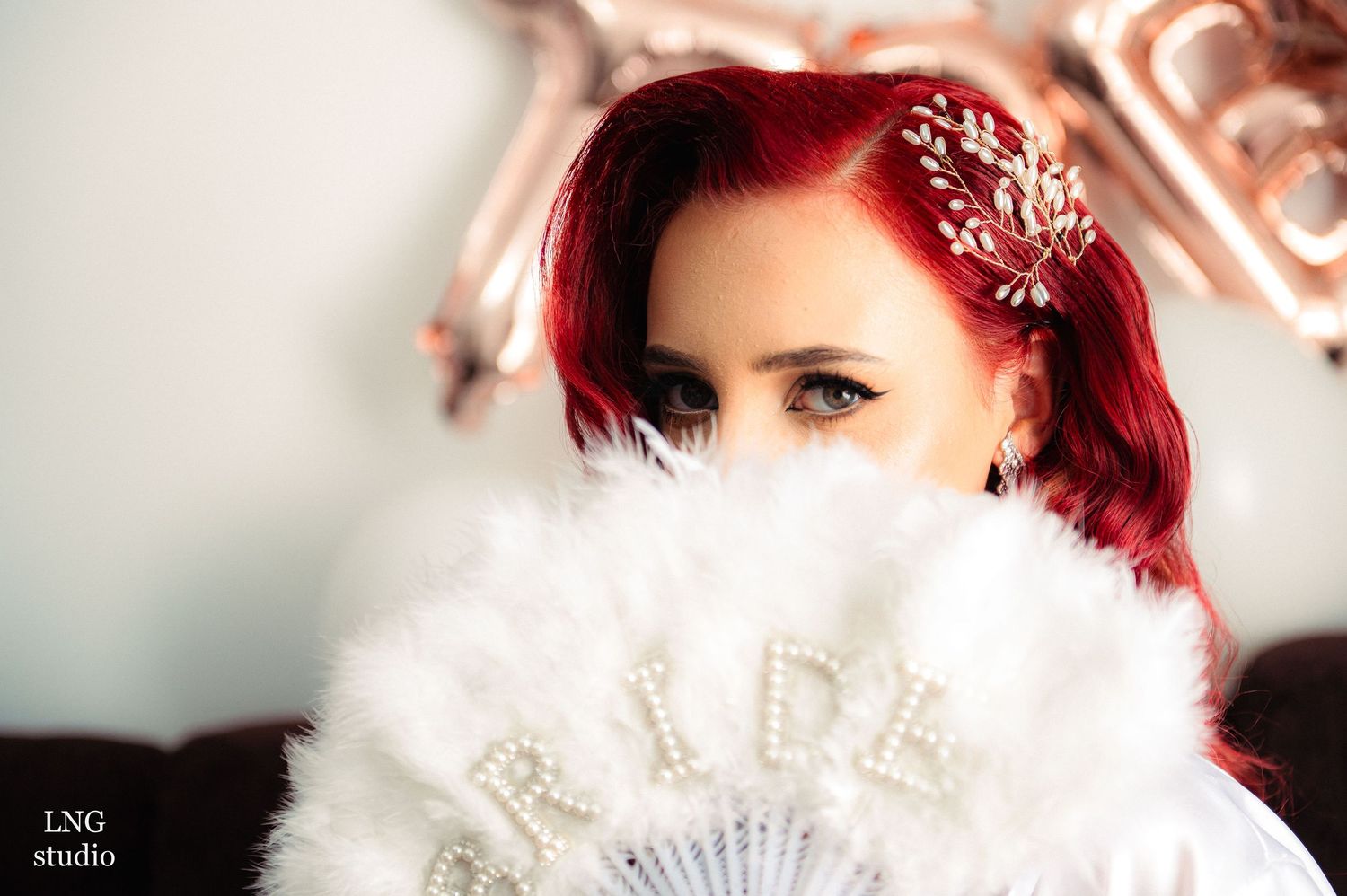 Glamorous bridal portrait featuring vintage-style fan and sparkly hair accessories.