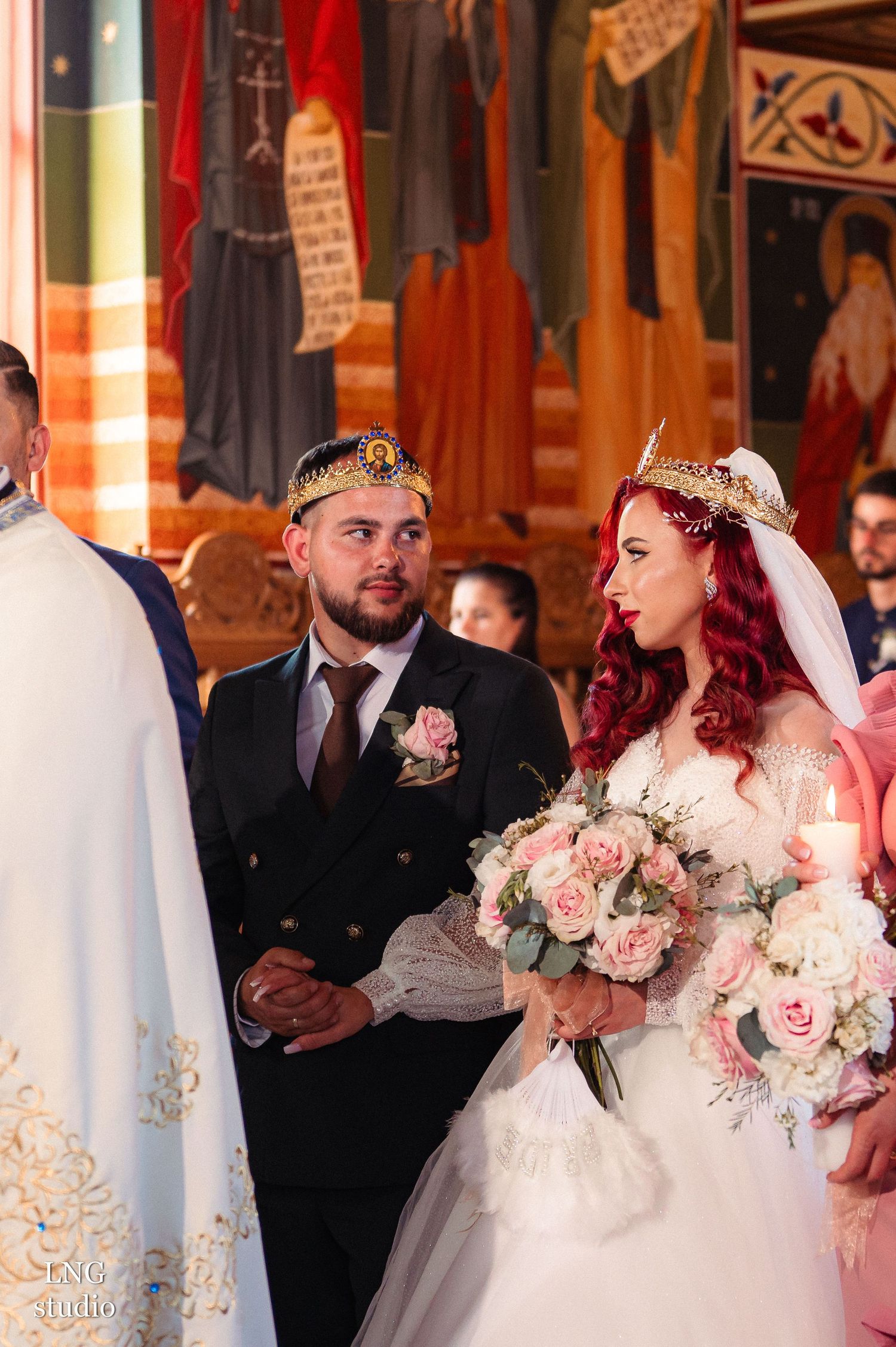 Orthodox wedding ceremony with bride holding pink rose bouquet in traditional church setting.