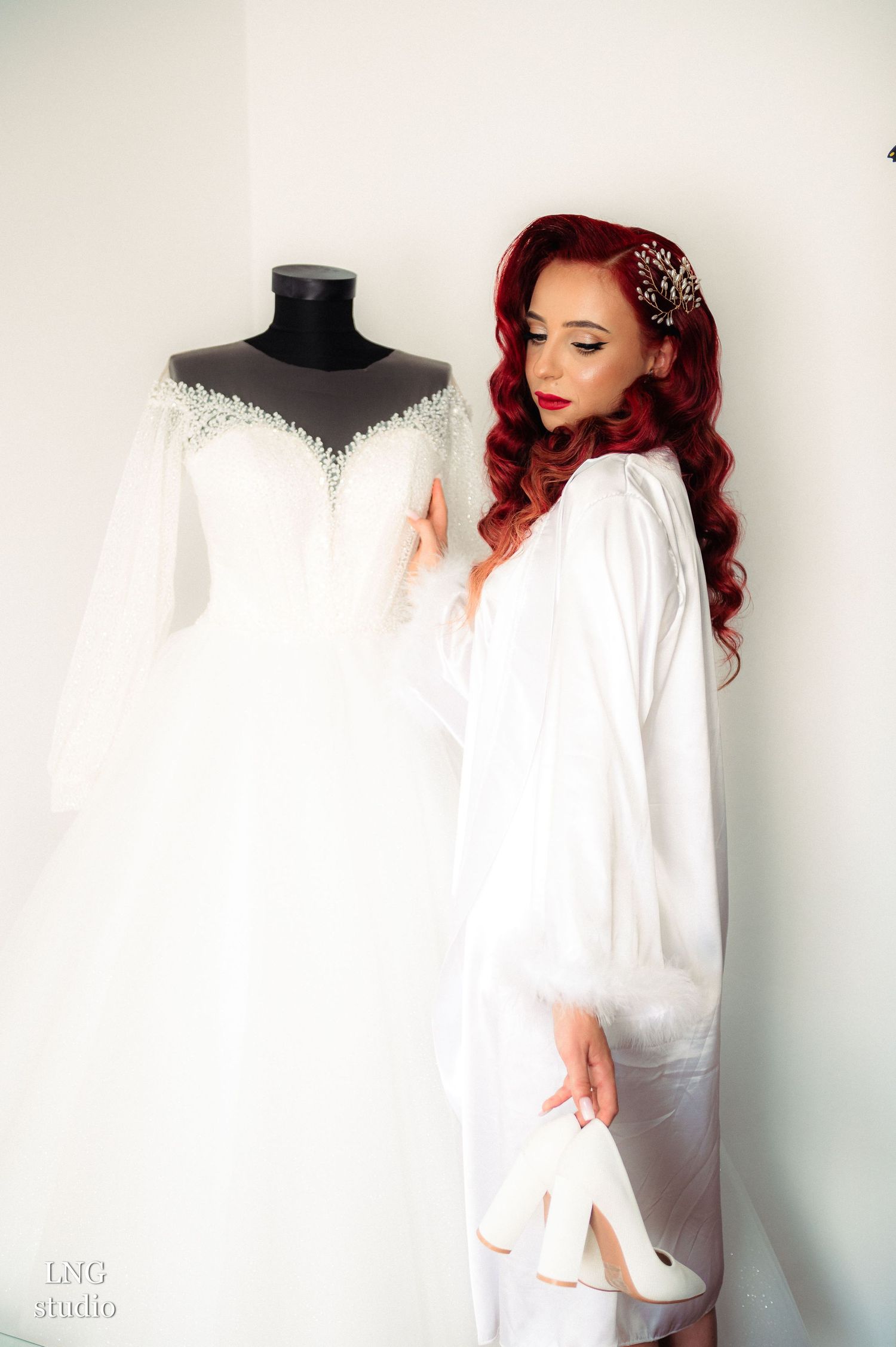 Classic bridal portrait with wedding dress display and white satin robe.