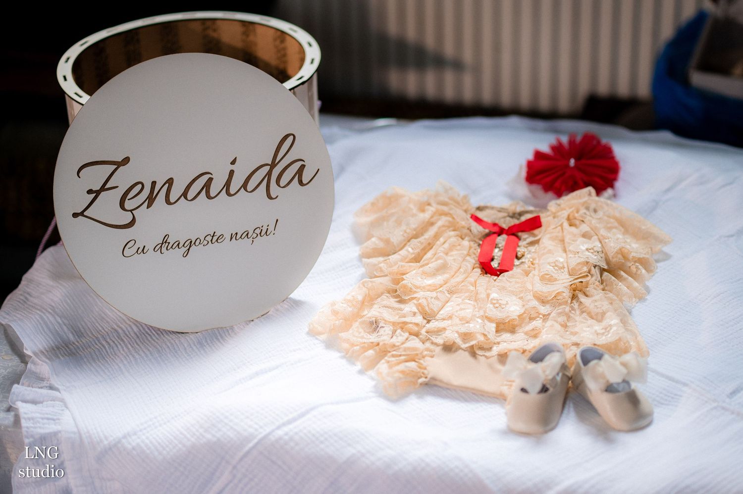 White christening gown and decorative items displayed with a personalized sign reading Zenaida.