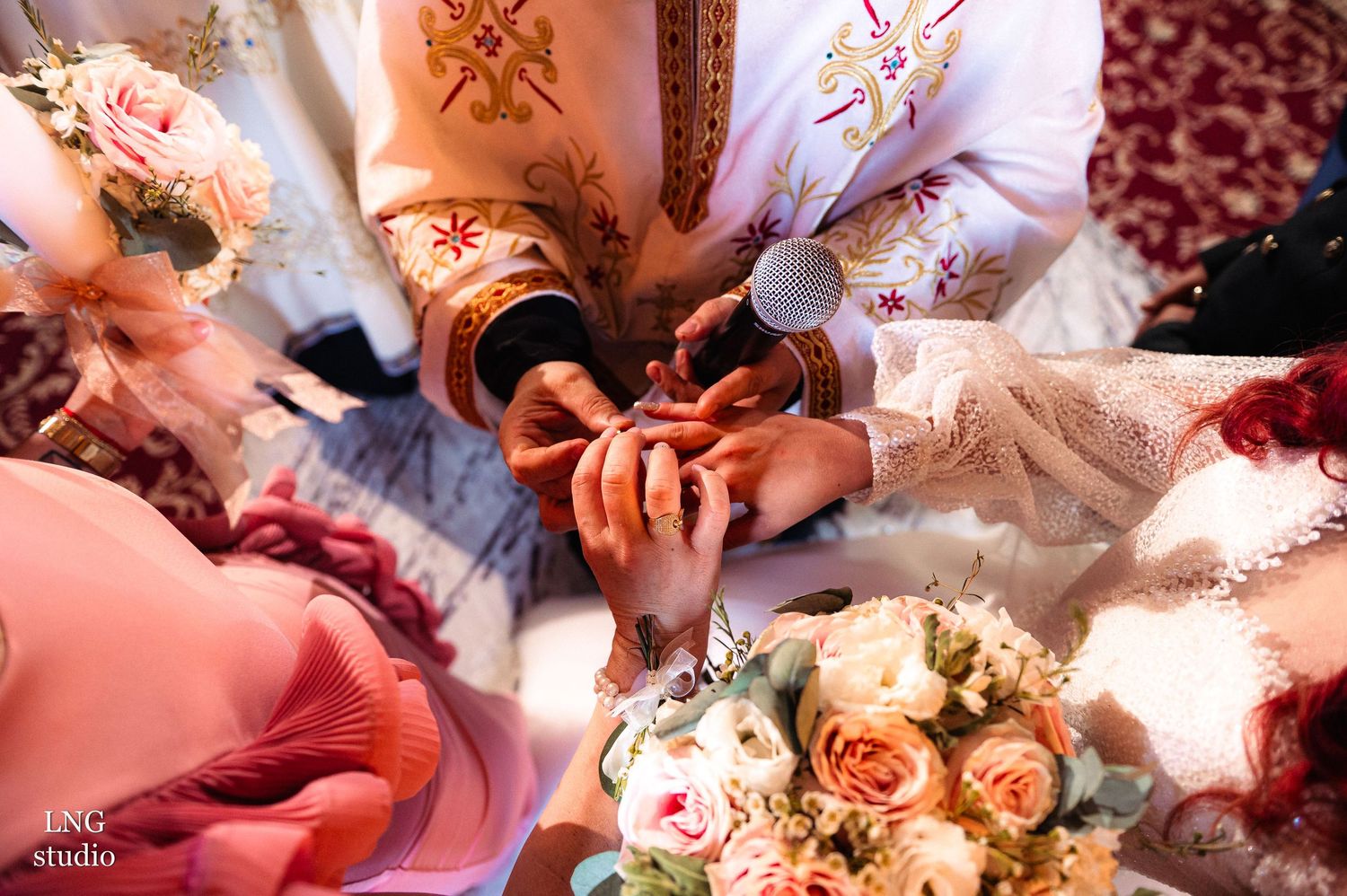 Wedding reception details with pink and peach floral arrangements on decorated tables.