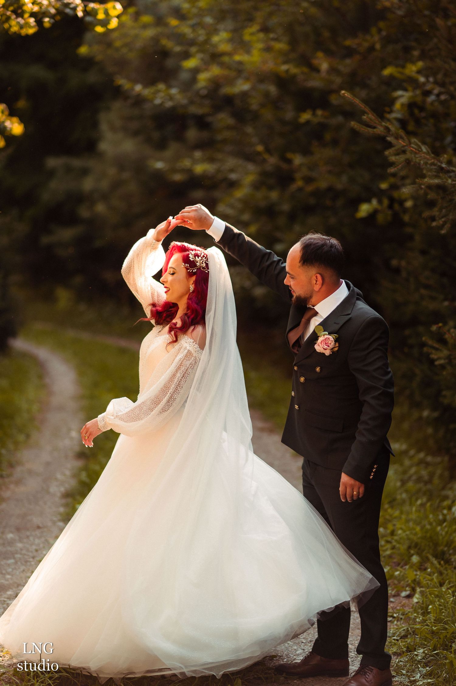 Playful dancing sequence of newlyweds on outdoor path surrounded by autumn foliage.
