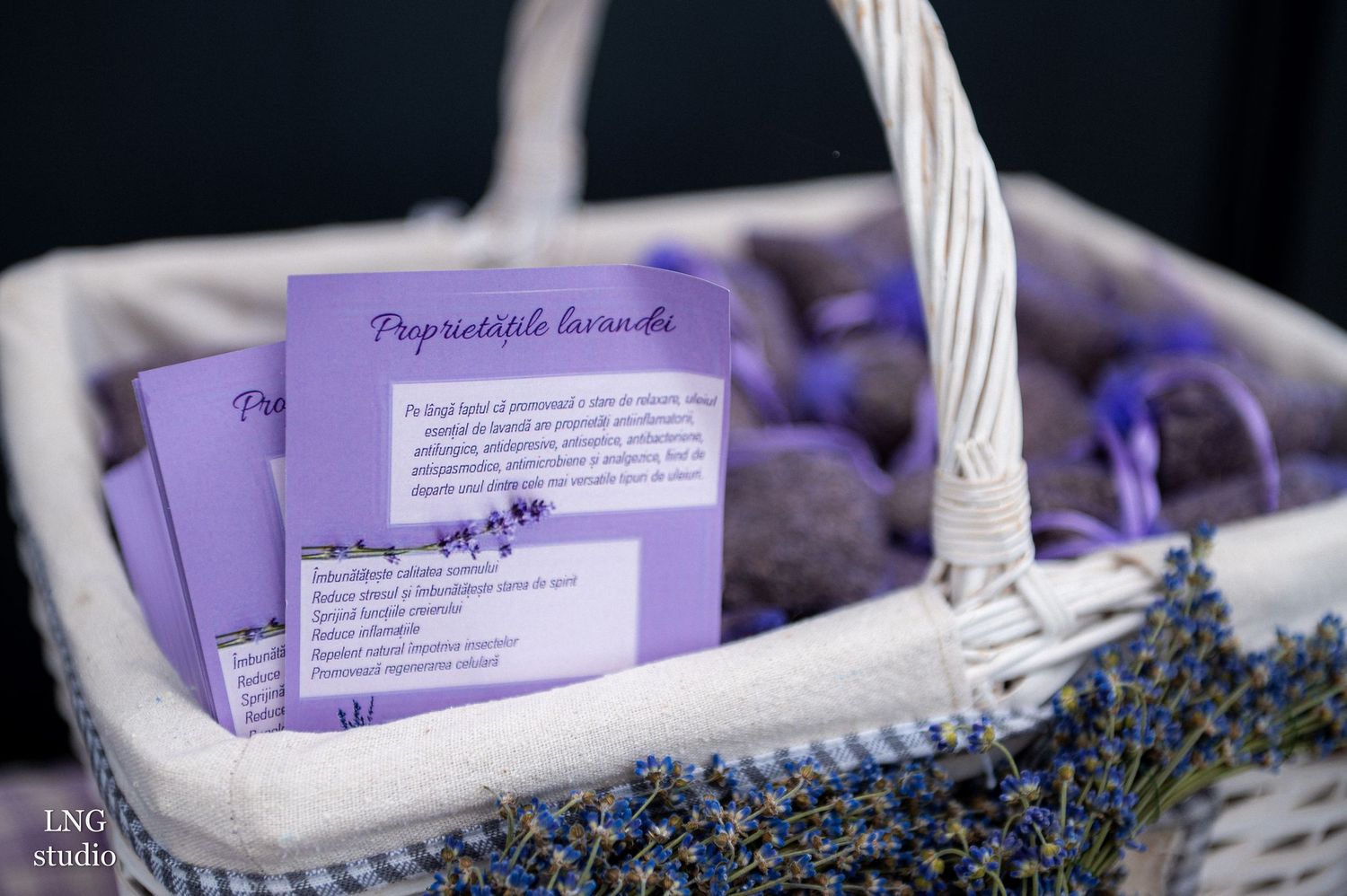 Purple event cards displayed in a white woven basket with lavender sprigs.