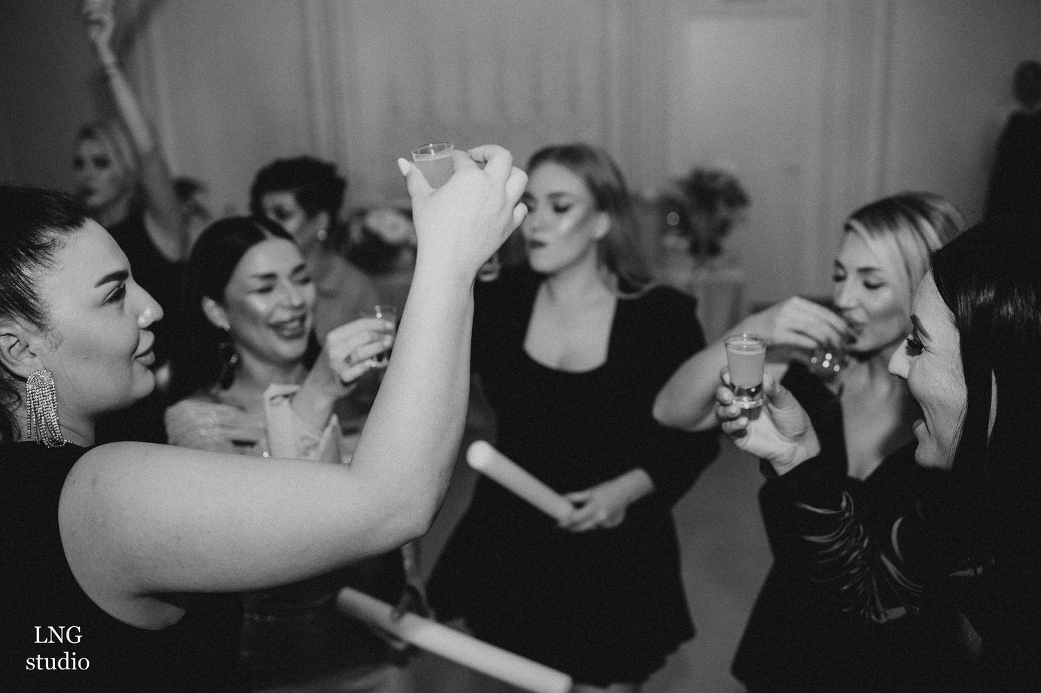 Black and white shot of people laughing and socializing at a party.