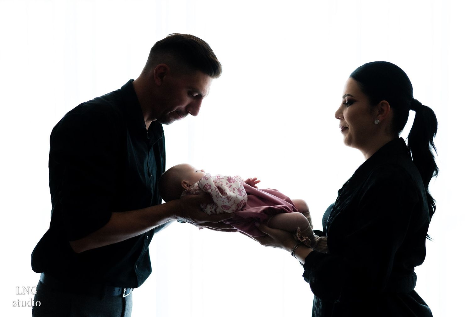 Artistic silhouette series captures family's intimate moments against white background.
