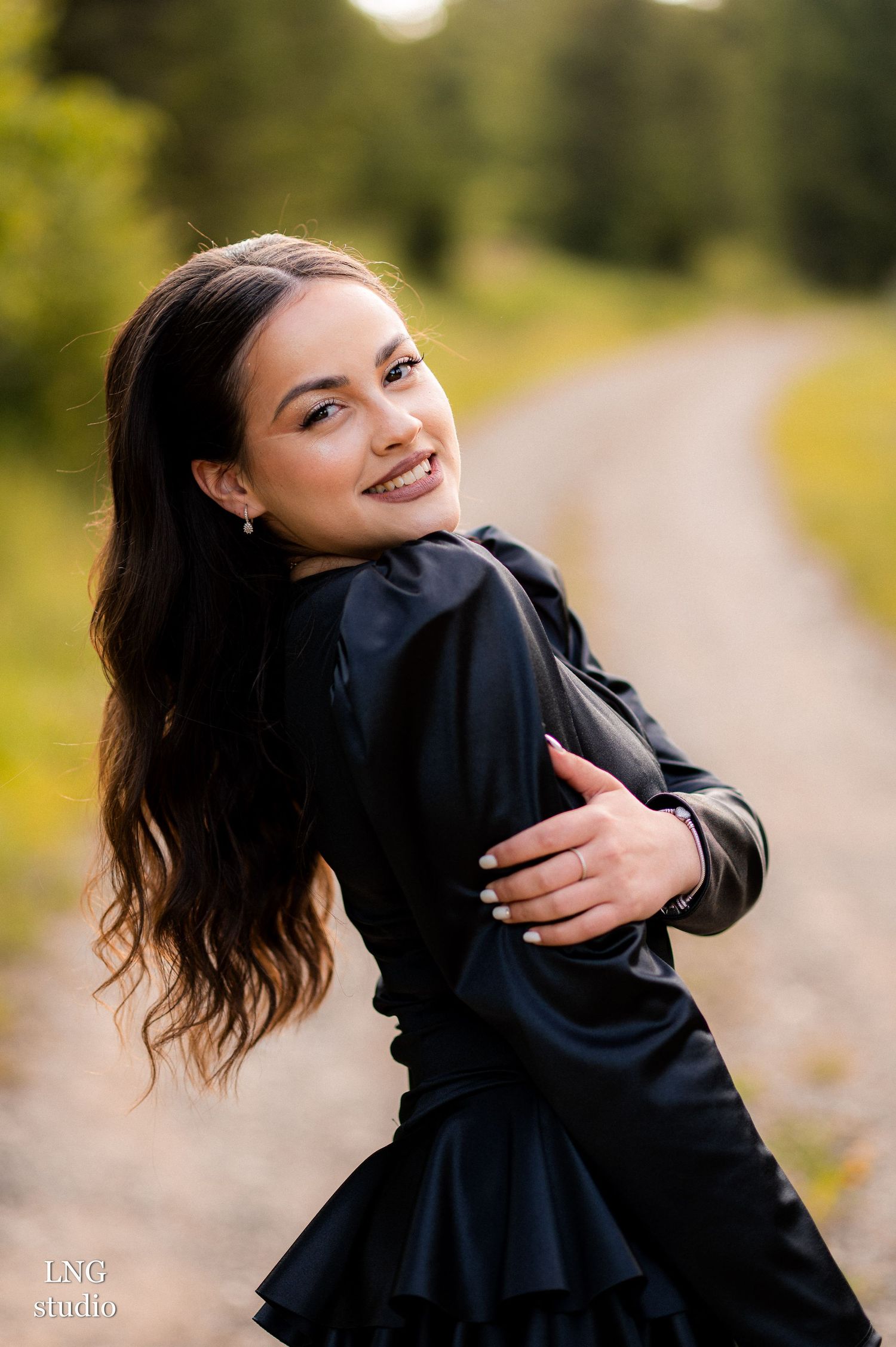 A series of artistic photos showing natural movement and flow of a black dress against a soft, outdoor background.