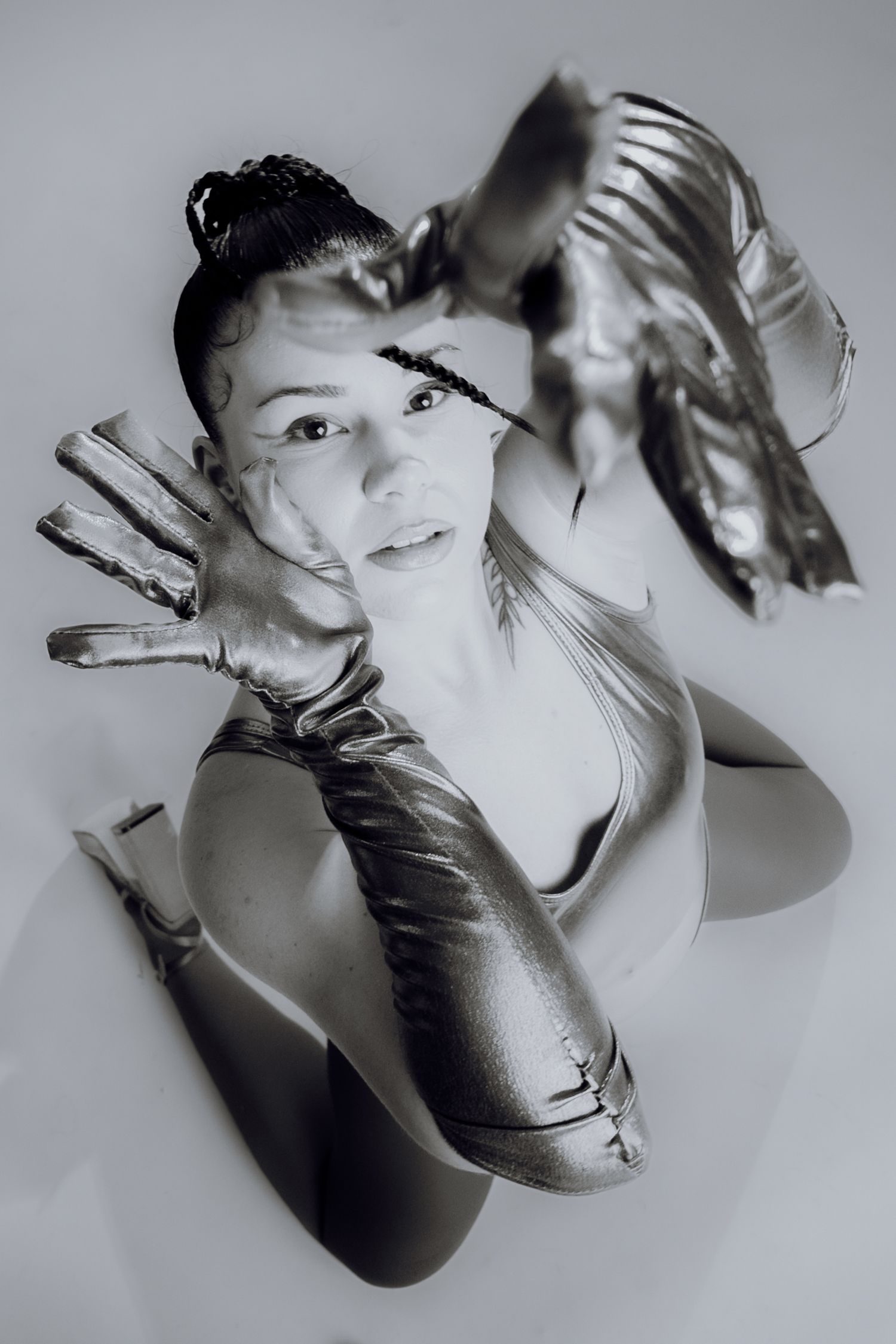Artistic fashion portrait of a woman posing with hands over her head in oversized gloves – Croatia