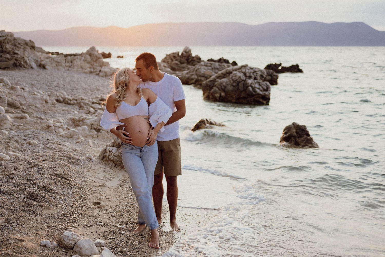 Pregnancy photoshoot of a couple at sunrise by the sea, natural light, Istria