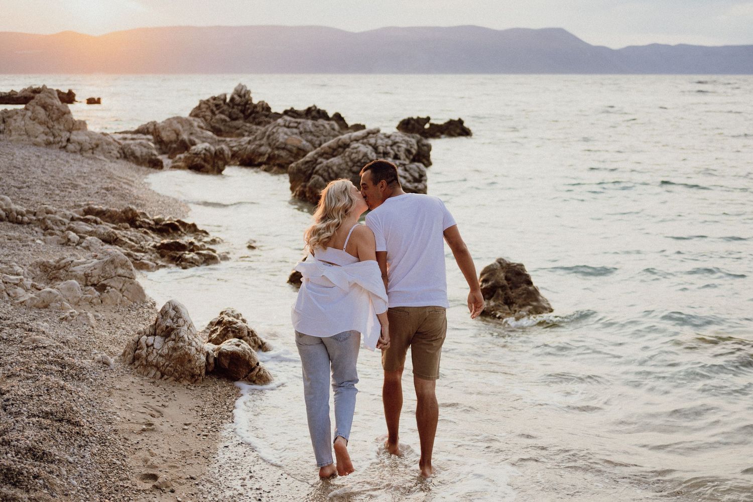 Pregnant couple enjoying a quiet morning by the sea before their baby arrives, Istria