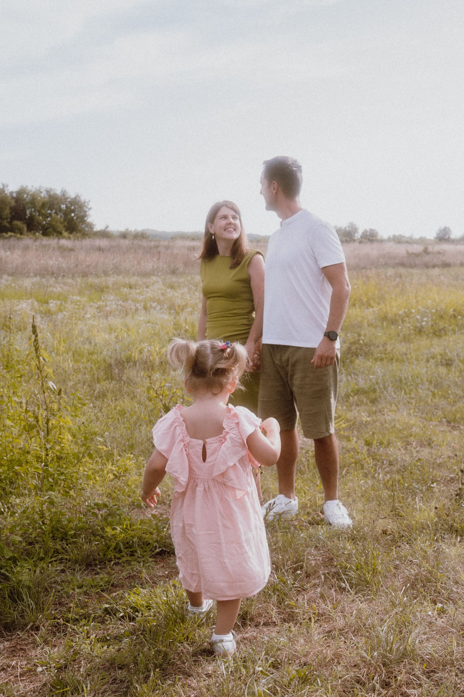 Family portrait with parents and their little girl in a natural o