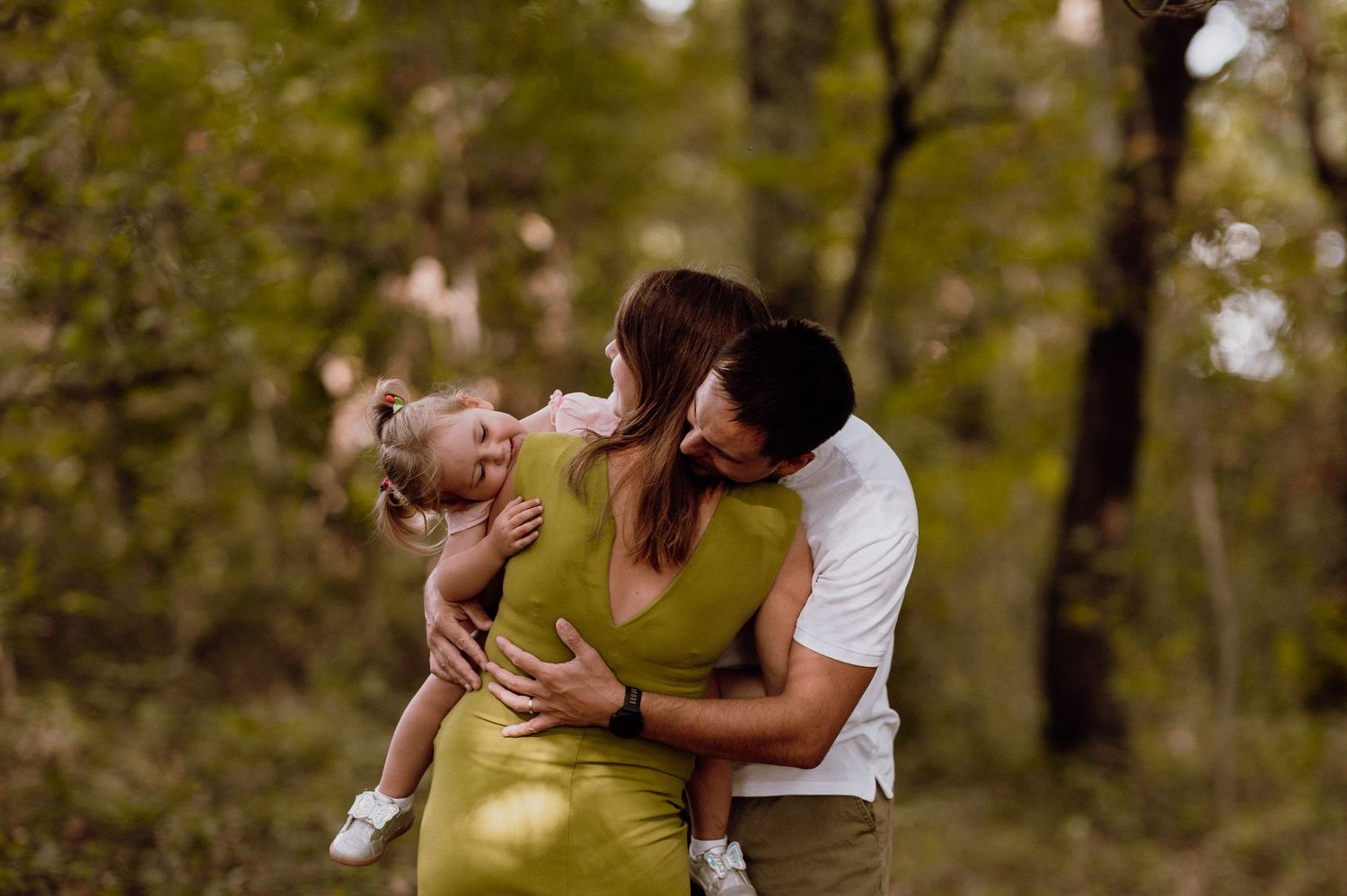 Parents playing and laughing with their young daughter outdoors in Croatia