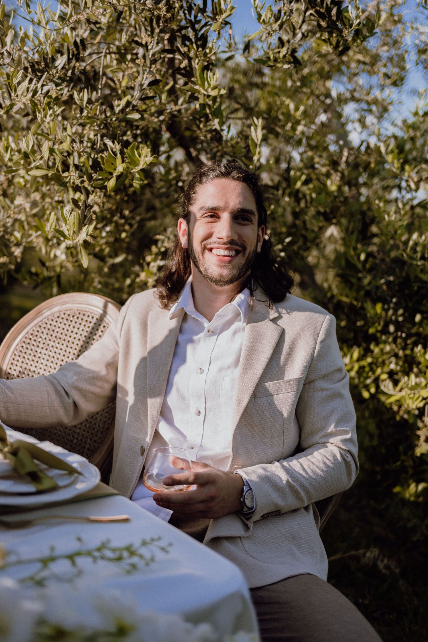 Groom posing confidently in a sunlit olive grove in Istria, Croatia