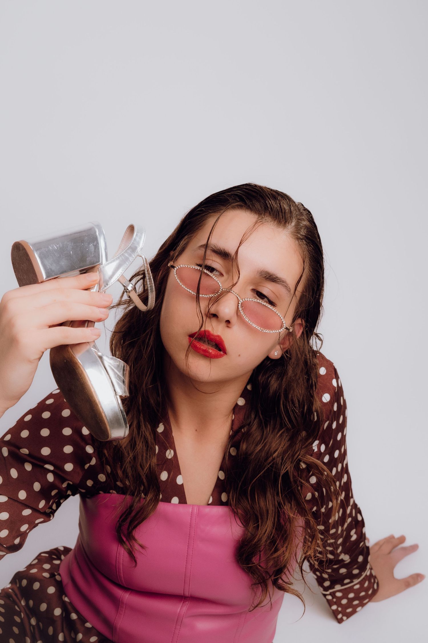 Model in avant-garde photoshoot holding a heel like a telephone – Croatia