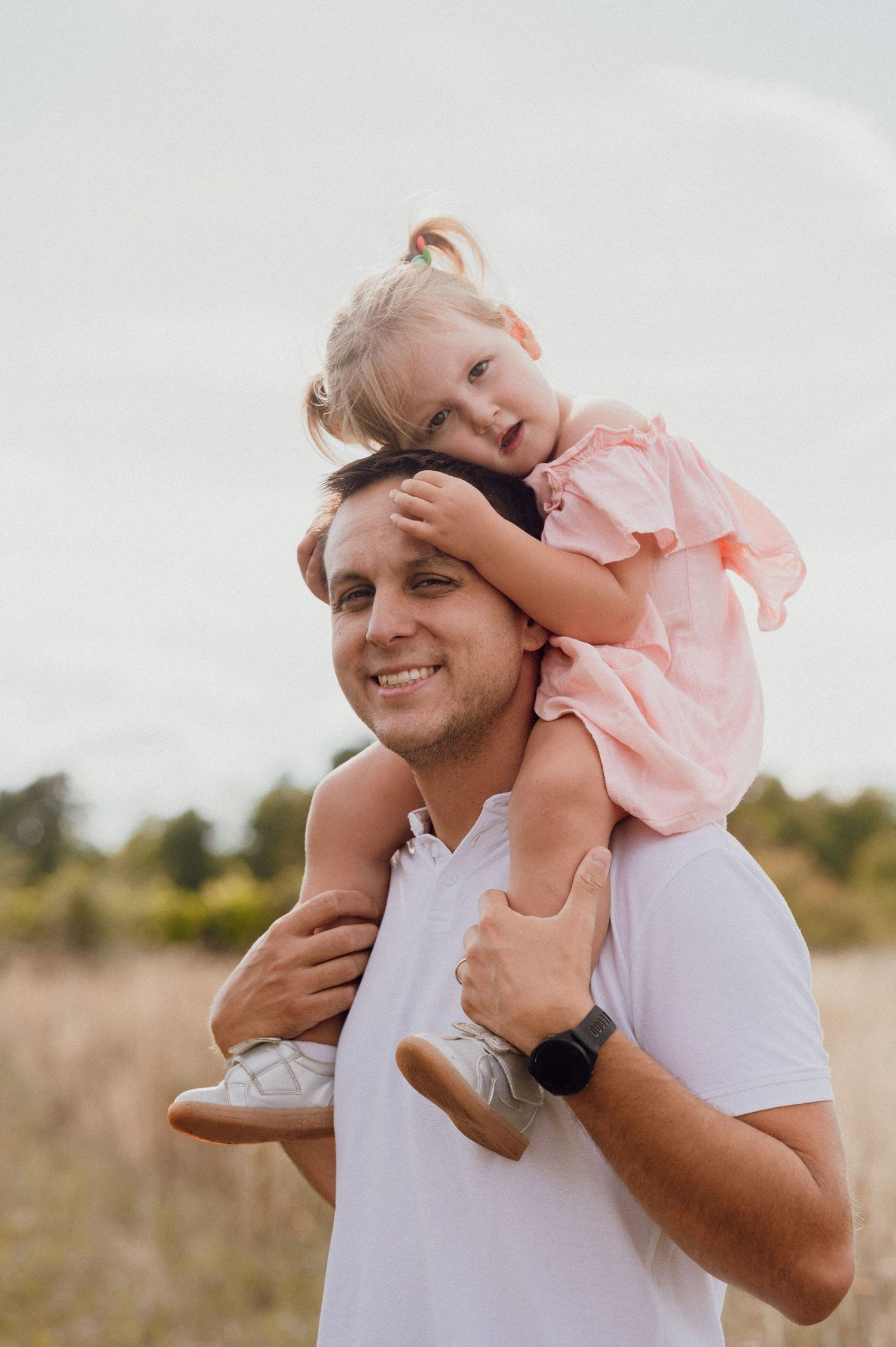 Father and daughter sharing a joyful moment outdoors in a sunlit park, Croatia