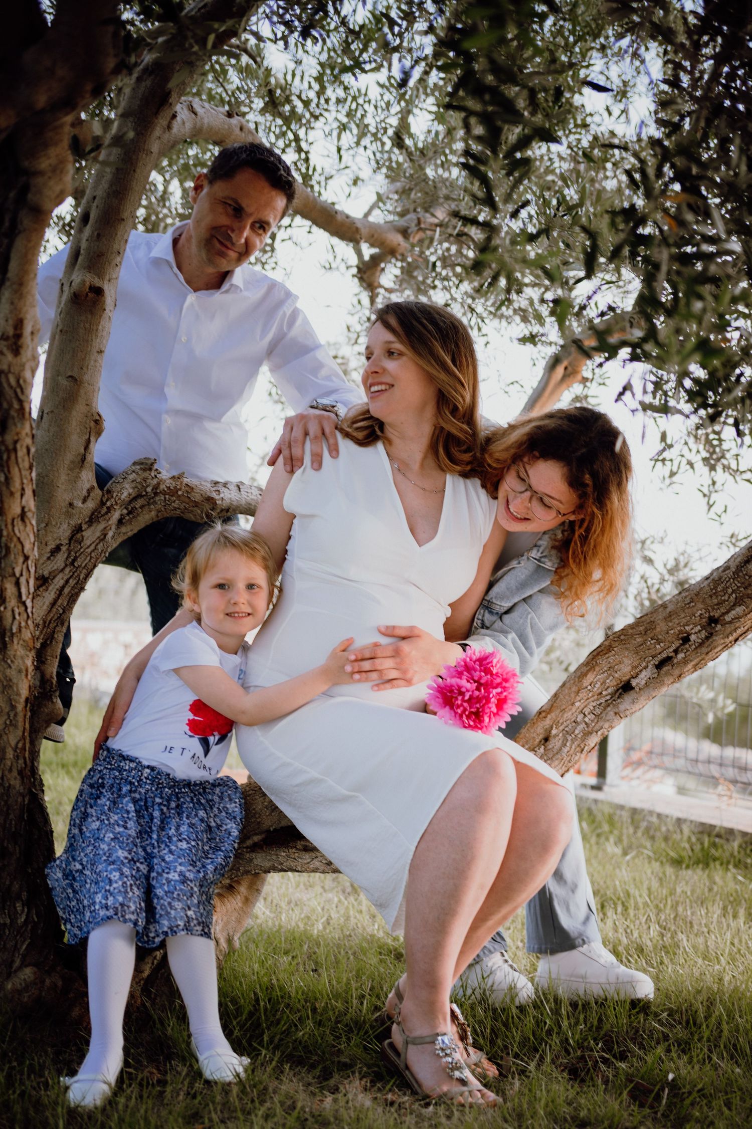Pregnant mother with husband and children enjoying family time in an olive grove, Istria