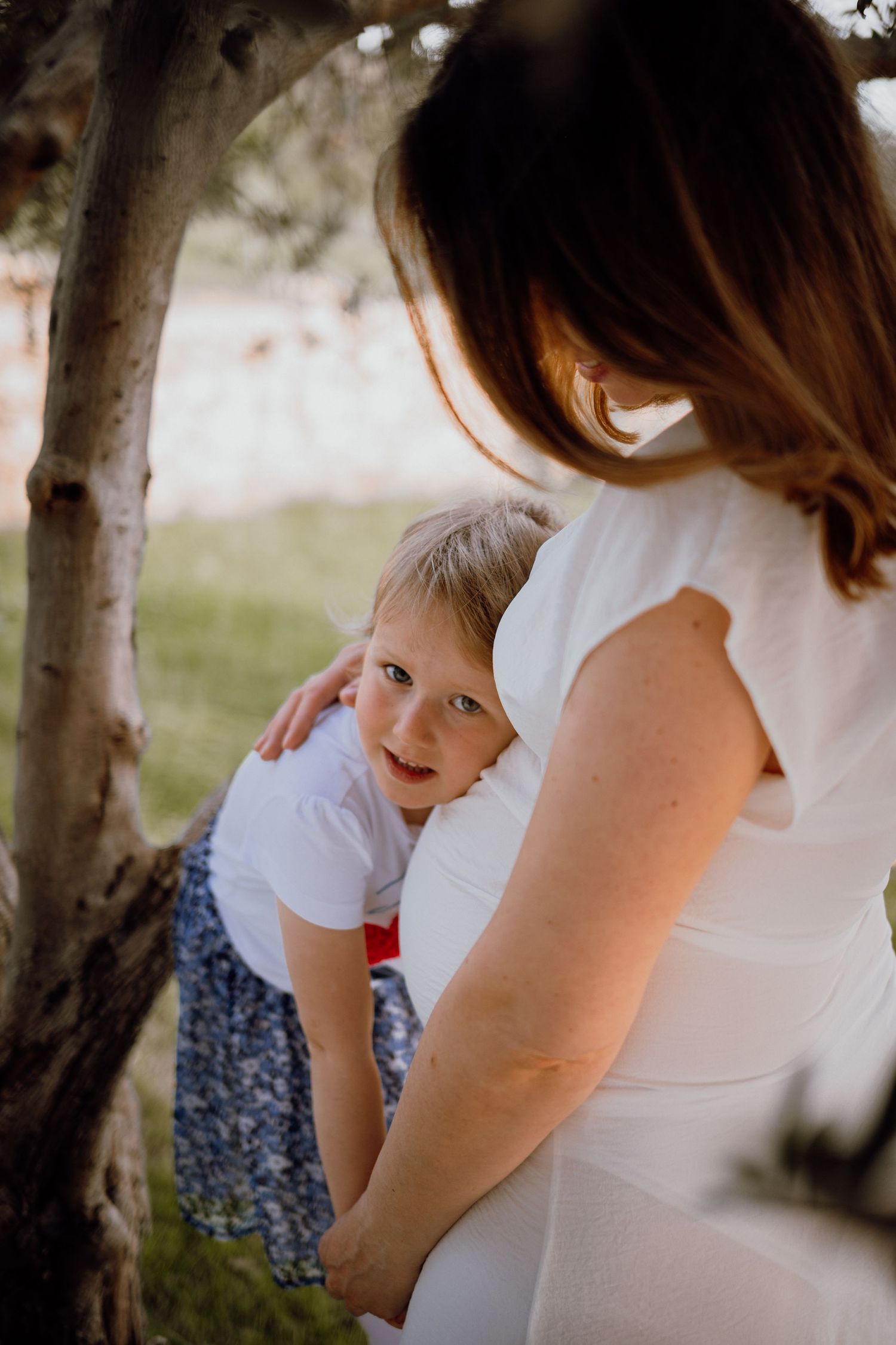 Family awaiting their new baby posing in a serene olive grove, Istria