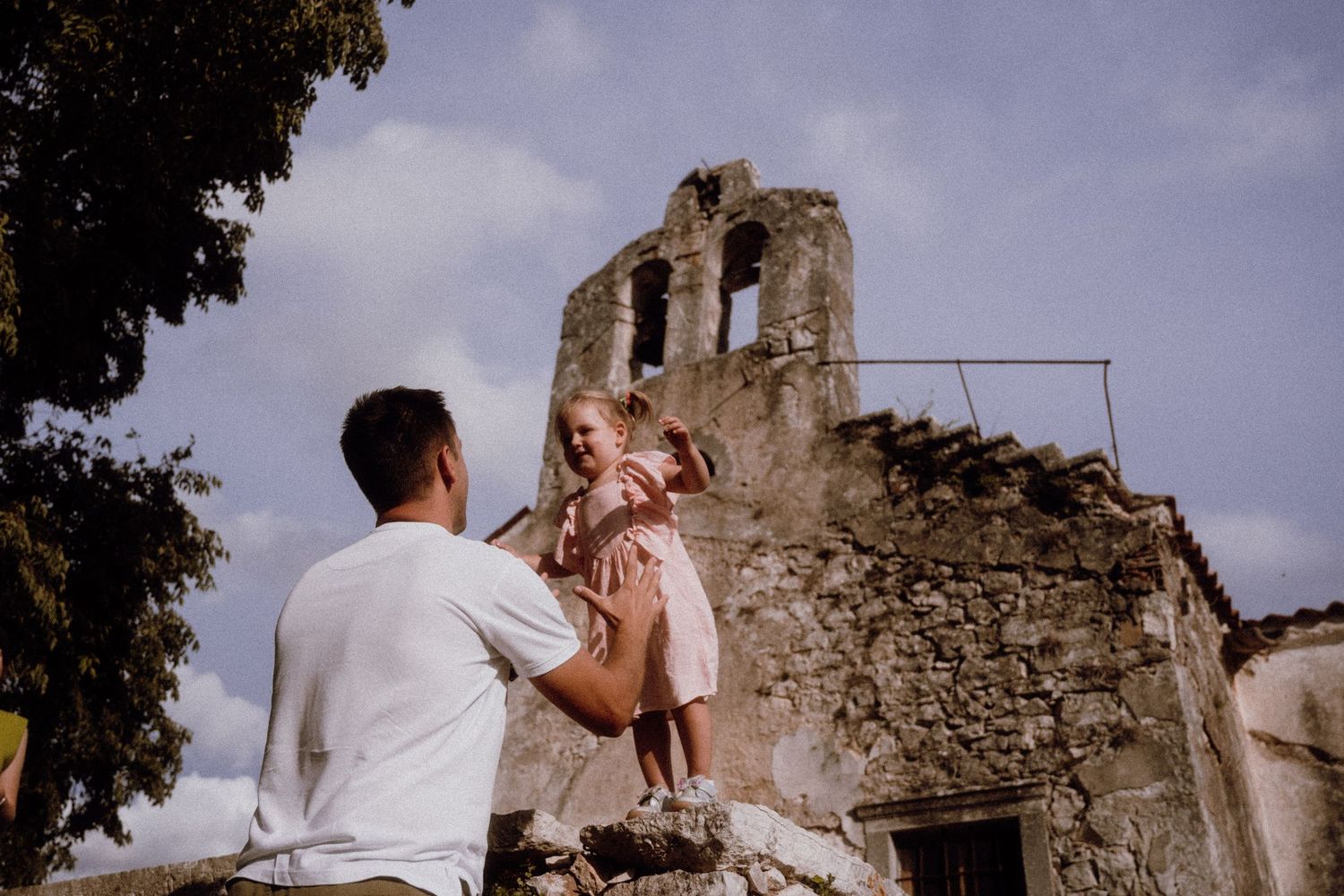 Dad embracing his little girl during a playful family photoshoot in Croatia