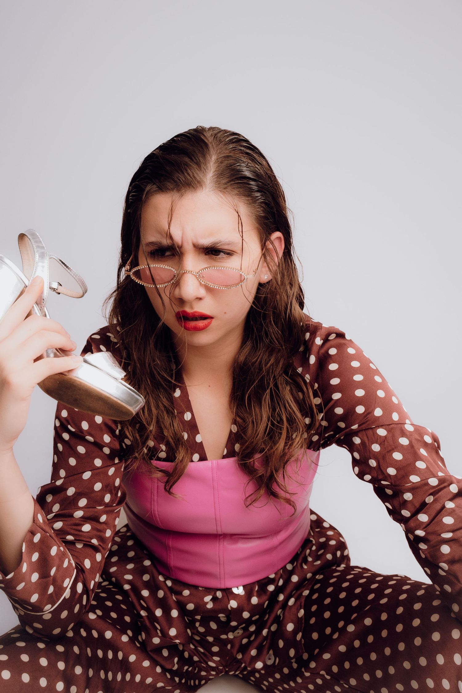 Fashion model creatively posing with a high heel as a phone – Croatia