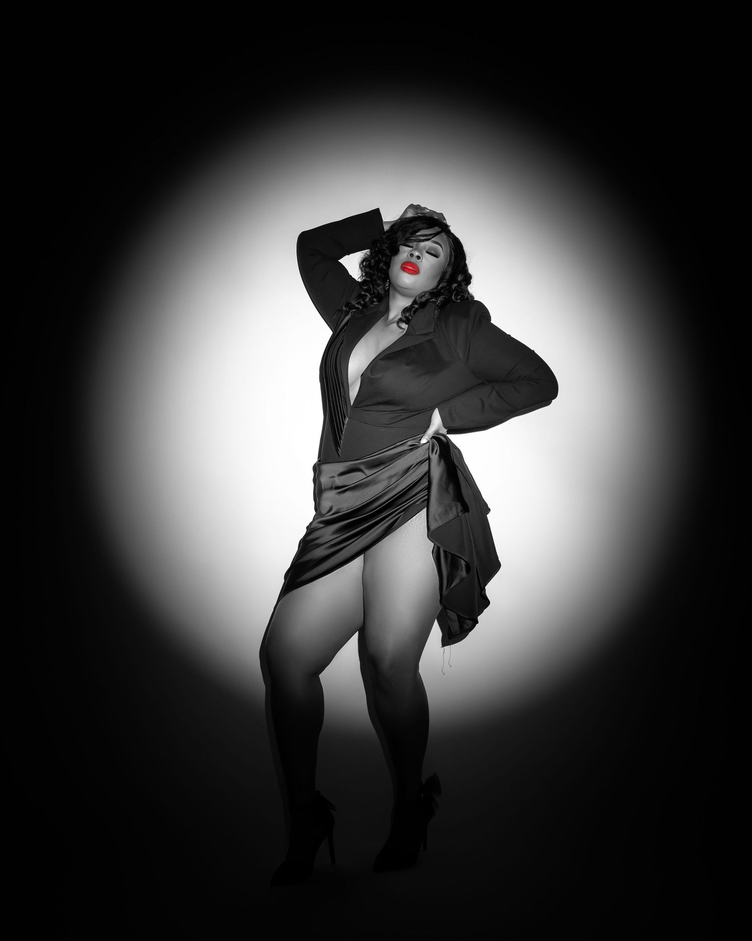 Artistic black and white portrait with dramatic lighting and pose.