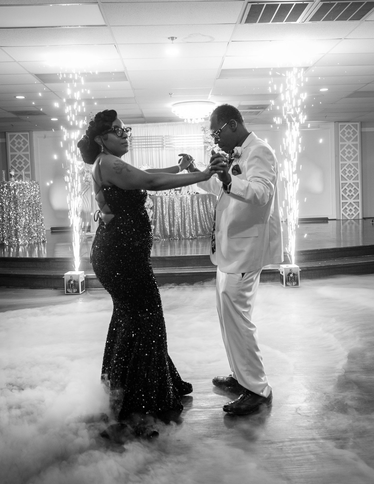 Black and white prom dance photo with sparkler effects and formal attire.