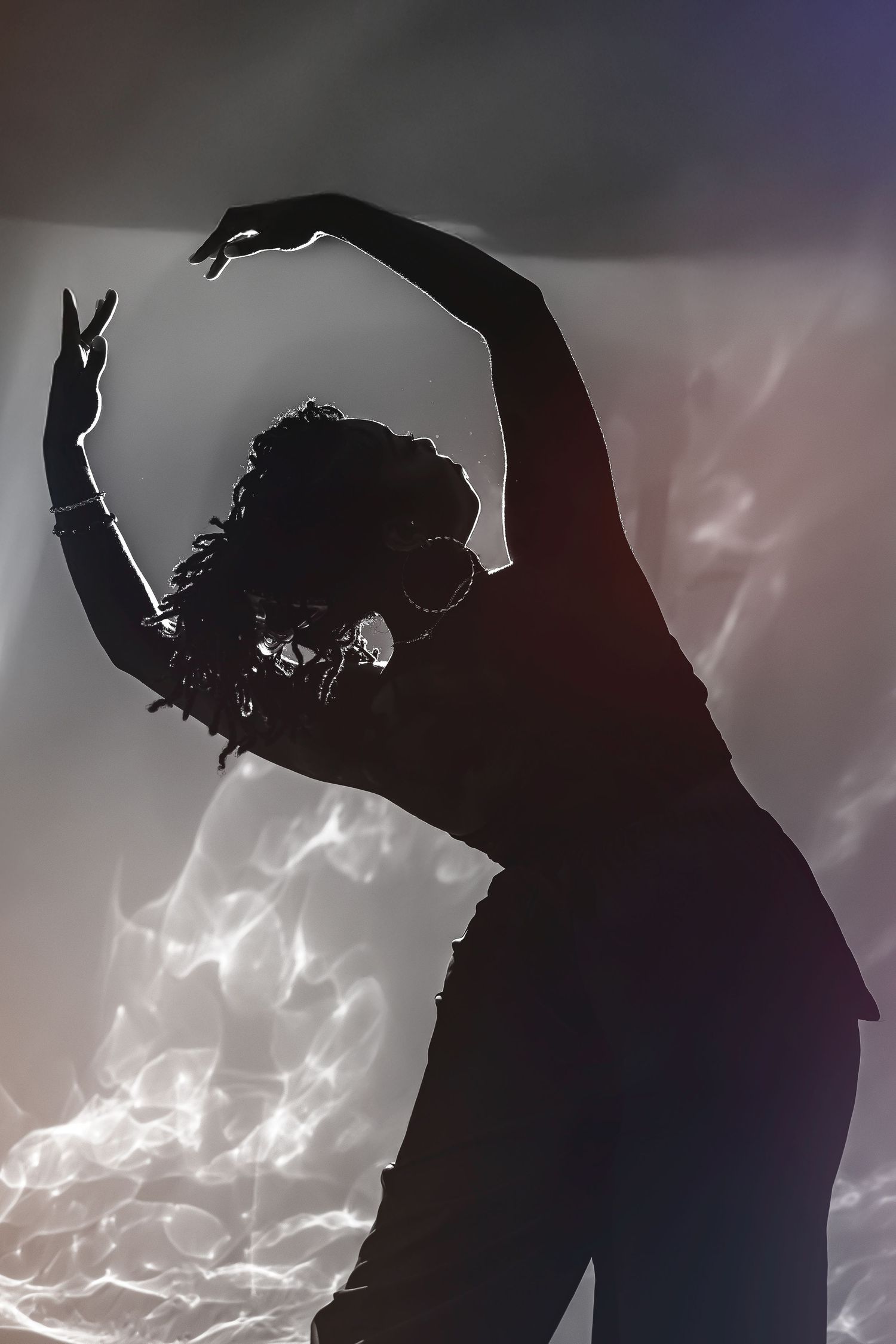 Dramatic silhouette of a dancer performing against a cloudy sky background.