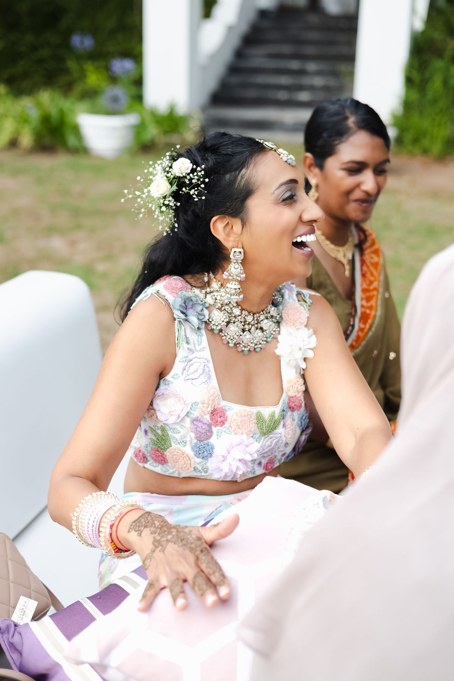 People in floral attire sharing joyful moments during an outdoor celebration.