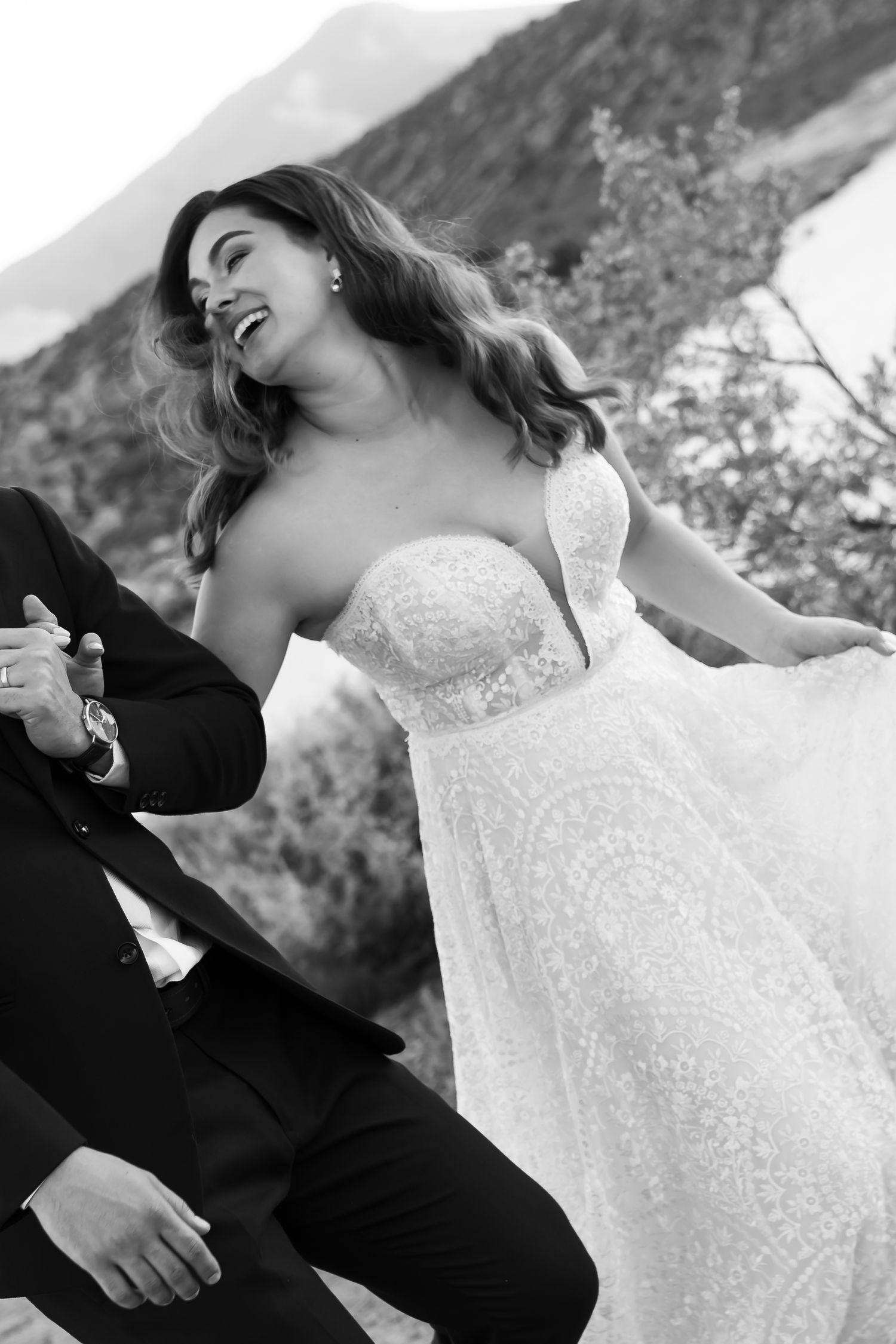 A romantic black and white photo of a couple embracing in formal wedding attire.