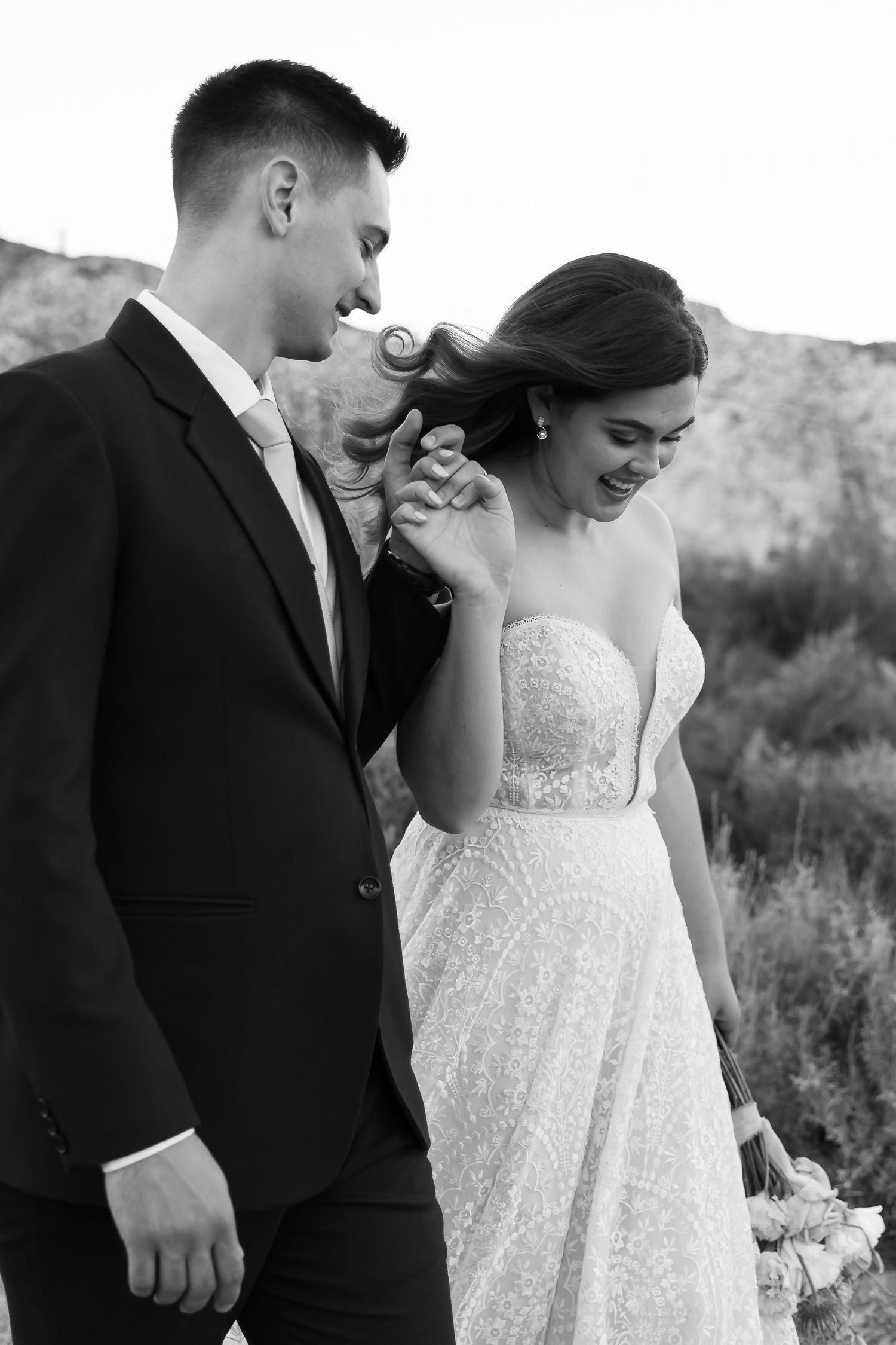 A romantic black and white wedding photo series showing tender moments between a couple in formal attire outdoors.