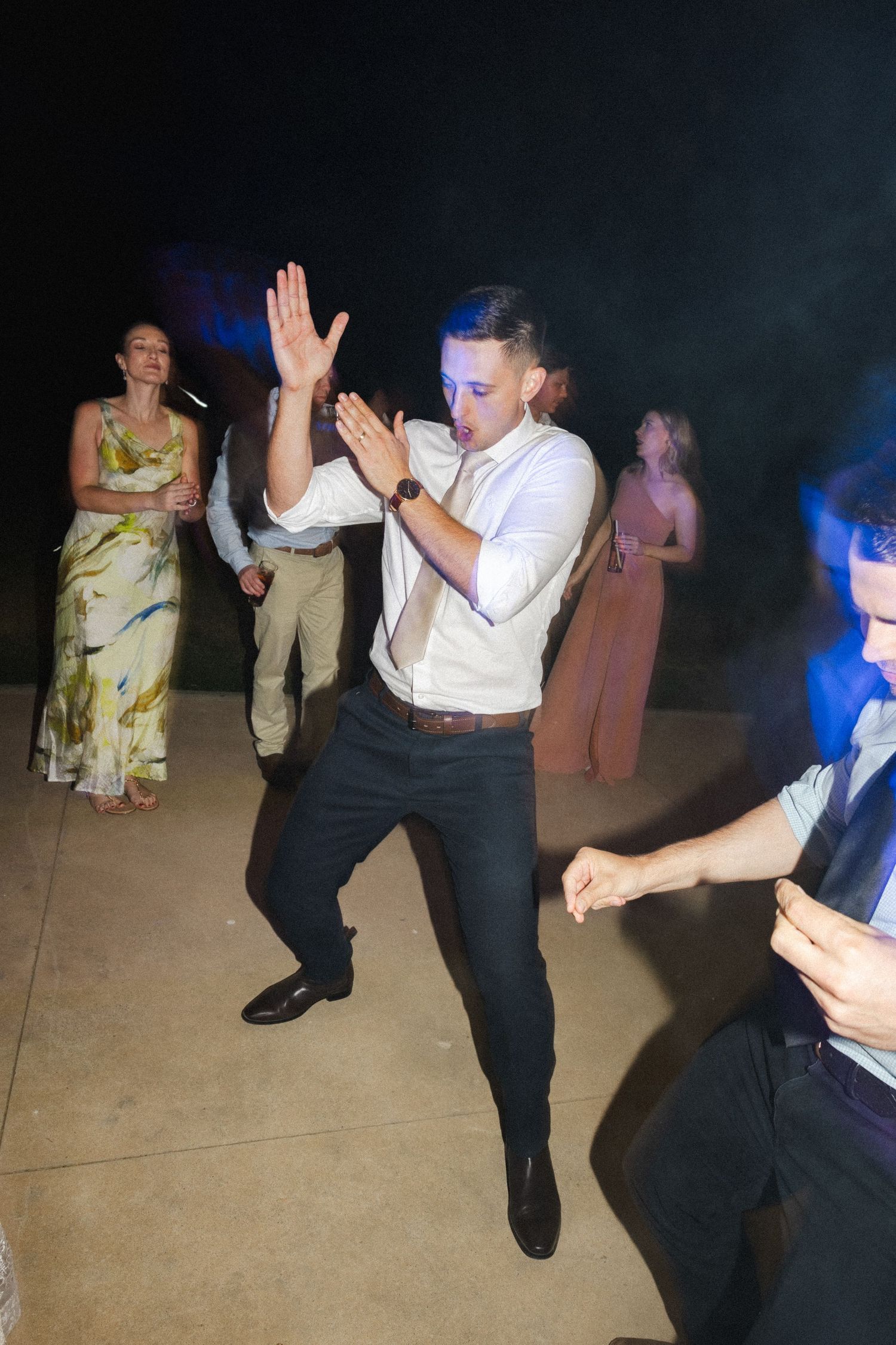 Energetic dance moves on display as guests celebrate at a nighttime party.