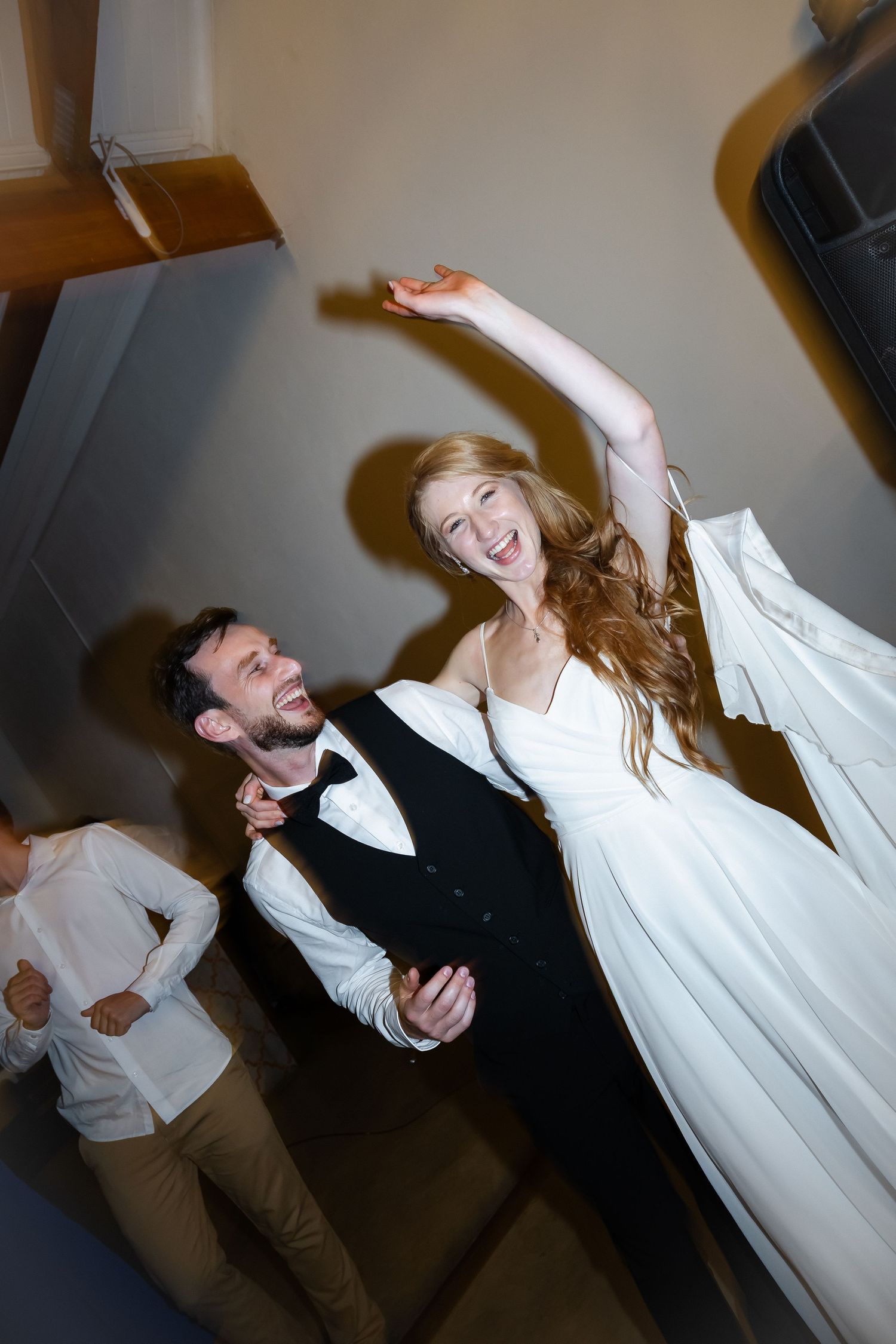 Joyful newlyweds dancing and laughing during their wedding celebration.
