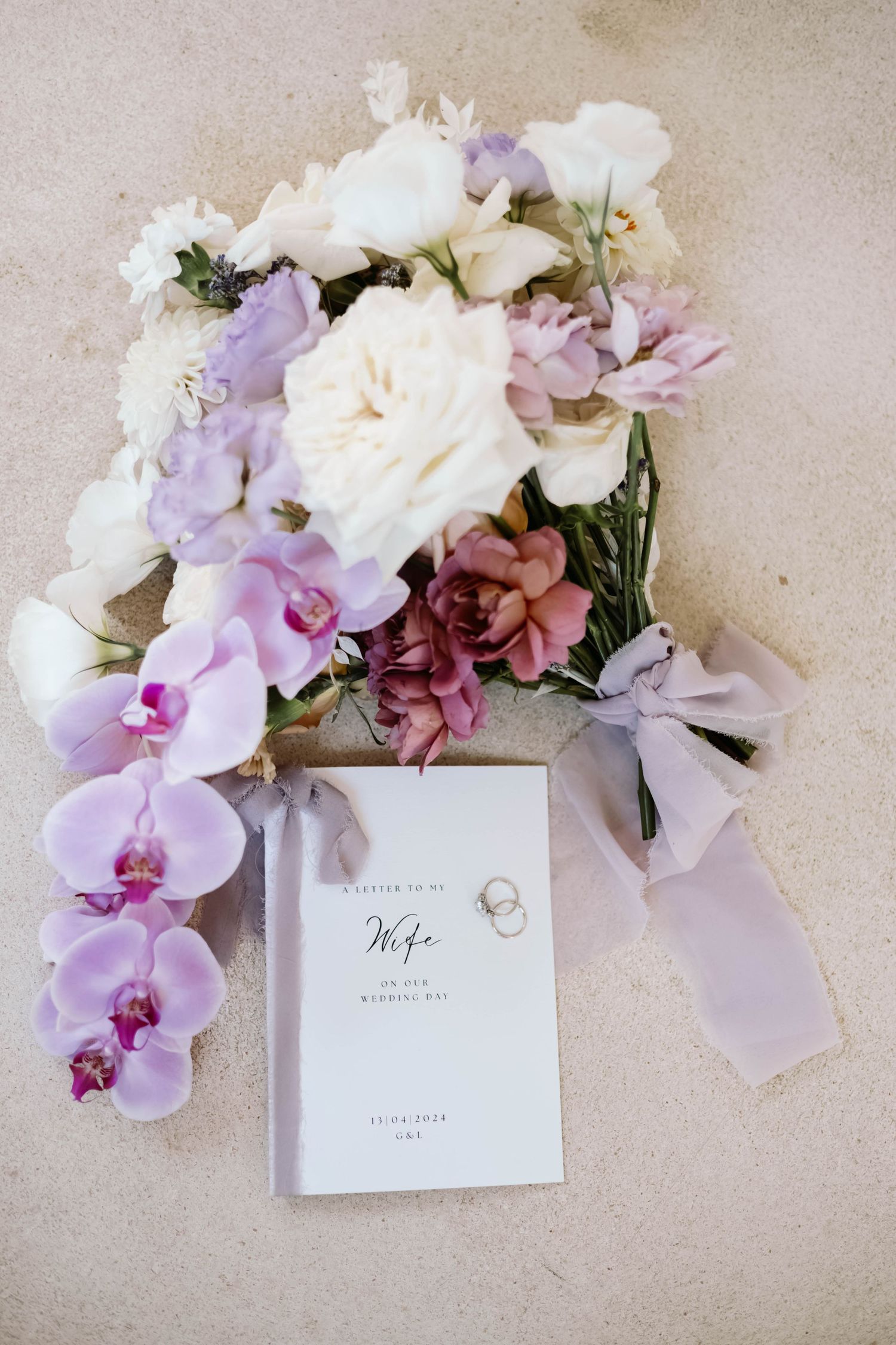 Wedding invitation suite styled with delicate pink and purple orchids.