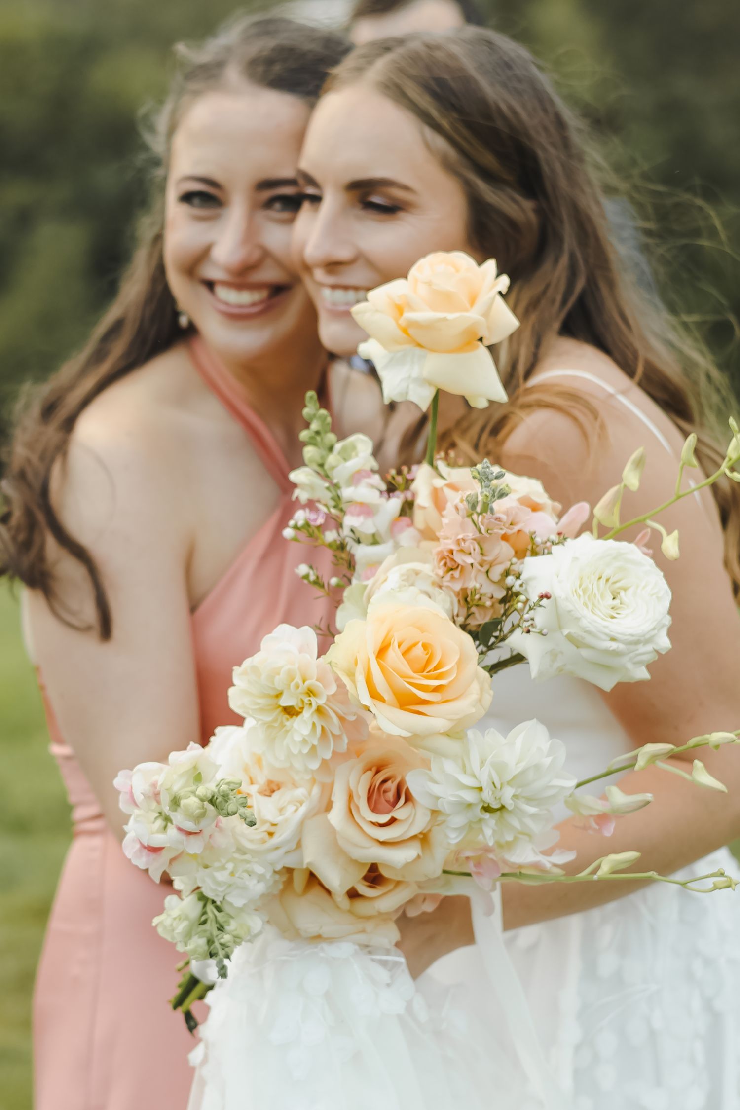 Elegant bridal bouquet featuring peach and white roses with delicate greenery.