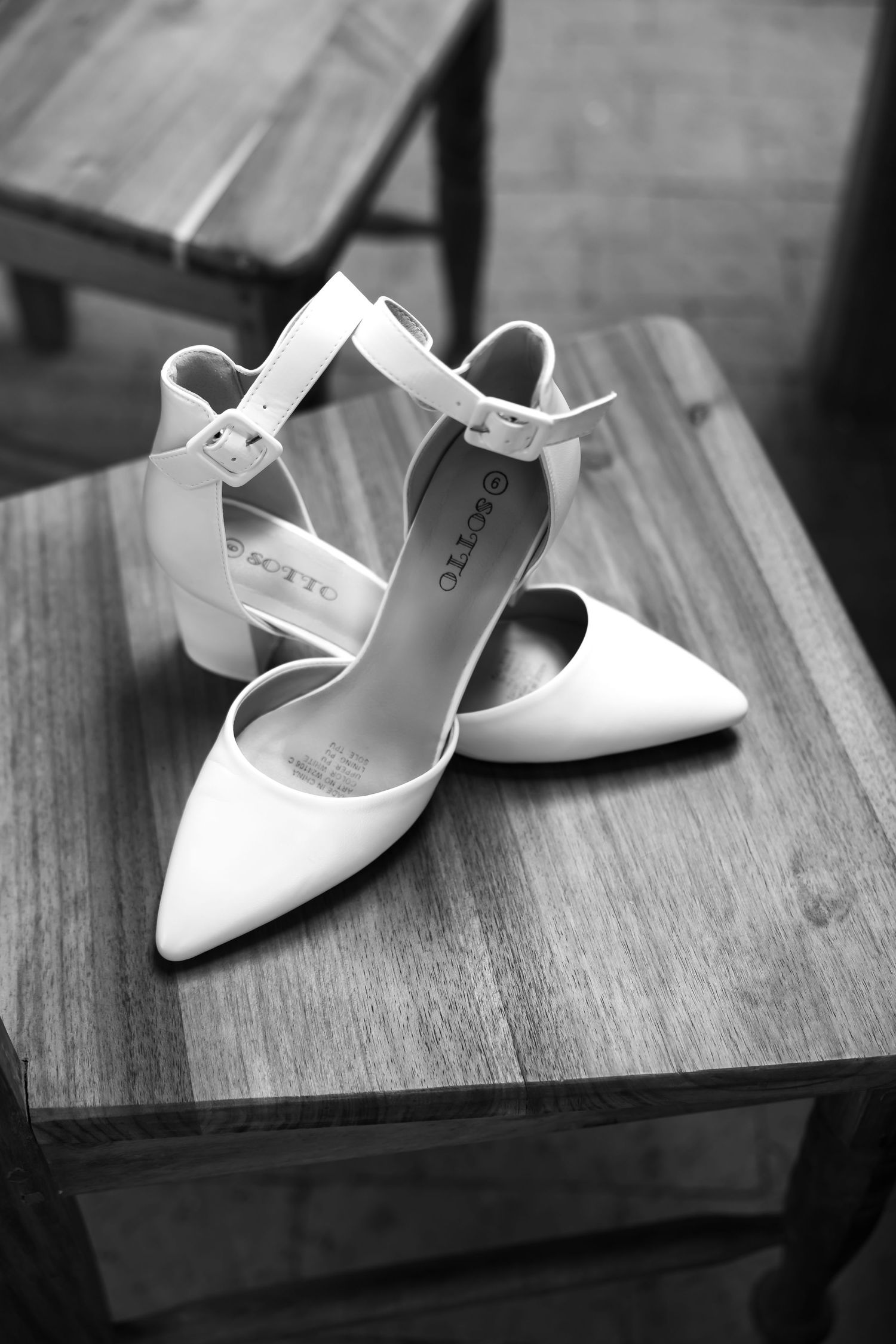A series of white bridal shoes arranged on a wooden surface shown from different angles.