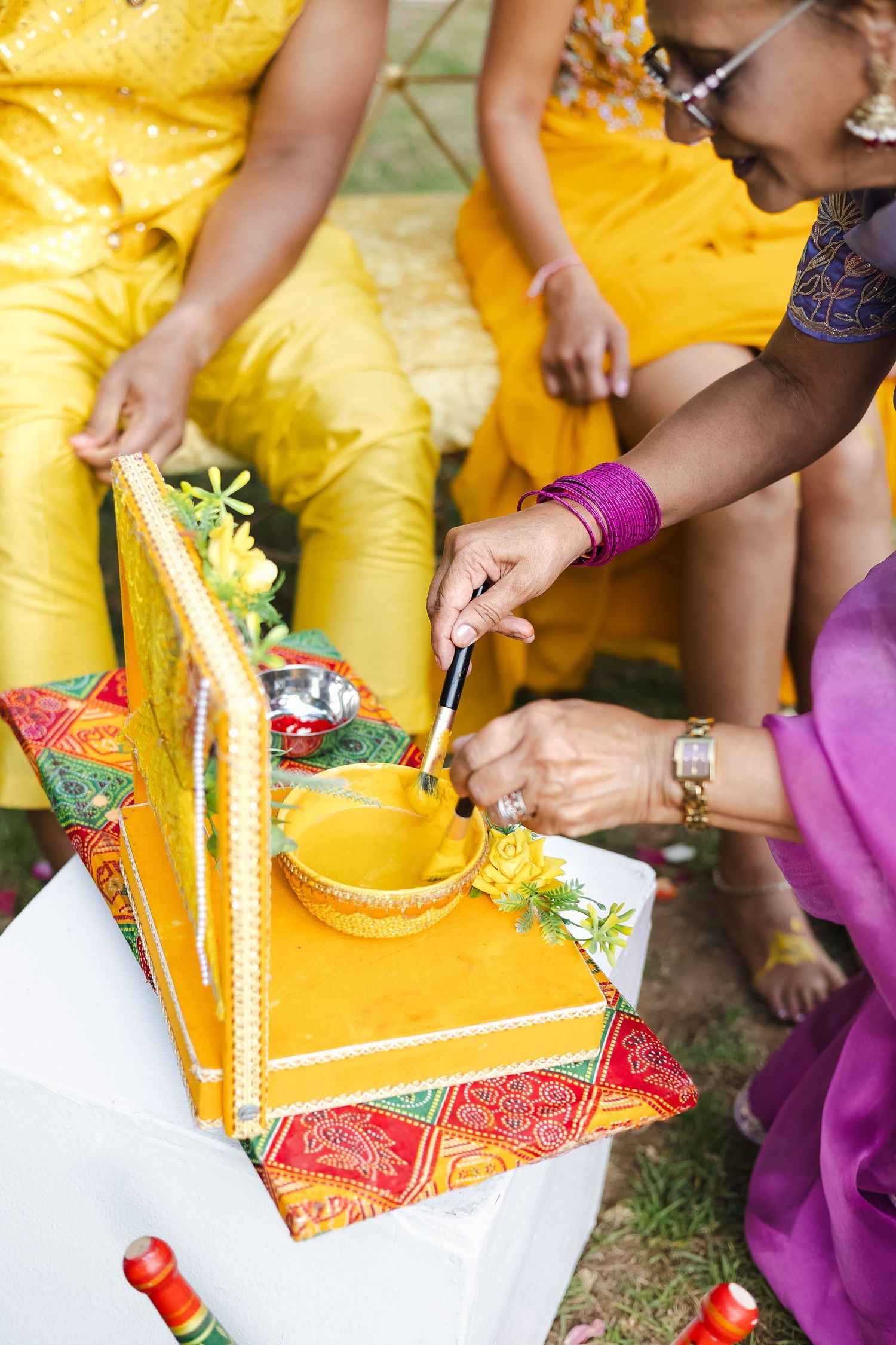 Detailed shots of hands holding traditional items and decorations during an Indian wedding ceremony.