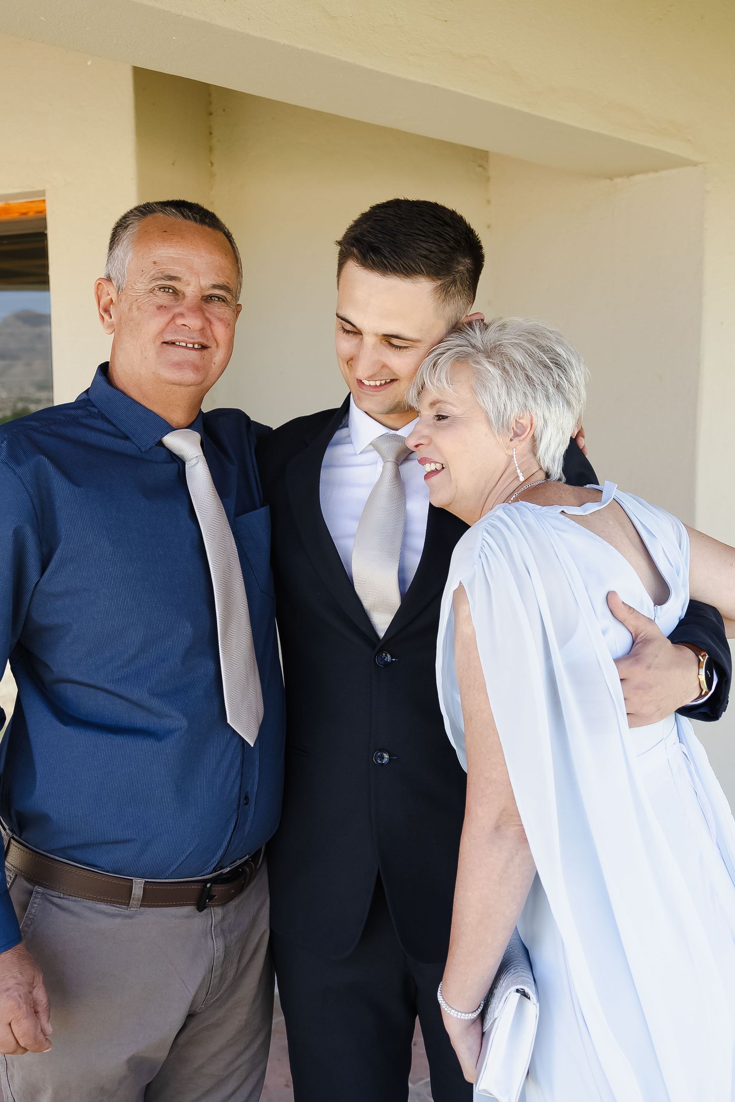 A heartwarming family moment shared between wedding party members embracing and smiling together.