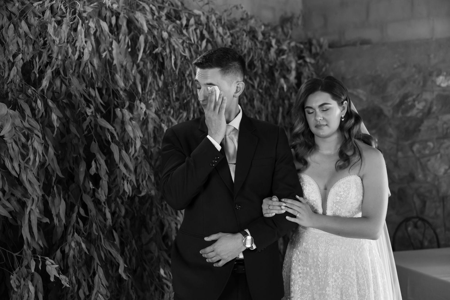 A series of black and white wedding photos showing romantic moments between a bride and groom outdoors.
